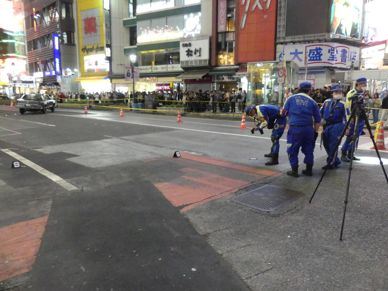 事故を起こして止まった車（左前方）のタイヤ痕などを調べる警視庁の担当者（撮影・中山知子）