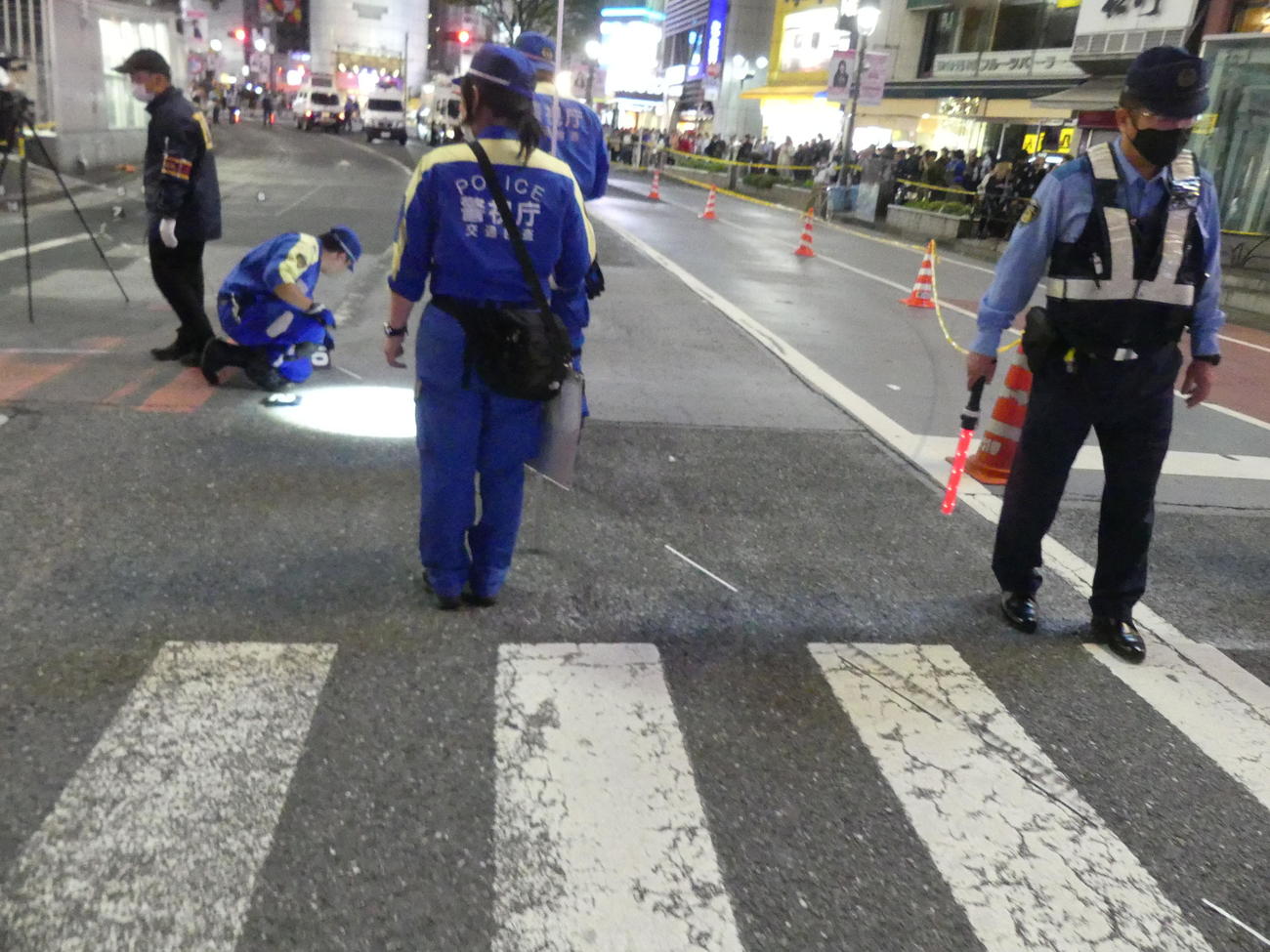 渋谷スクランブル交差点近くで事故を起こした車のタイヤ痕を調べる警視庁担当者（撮影・中山知子）