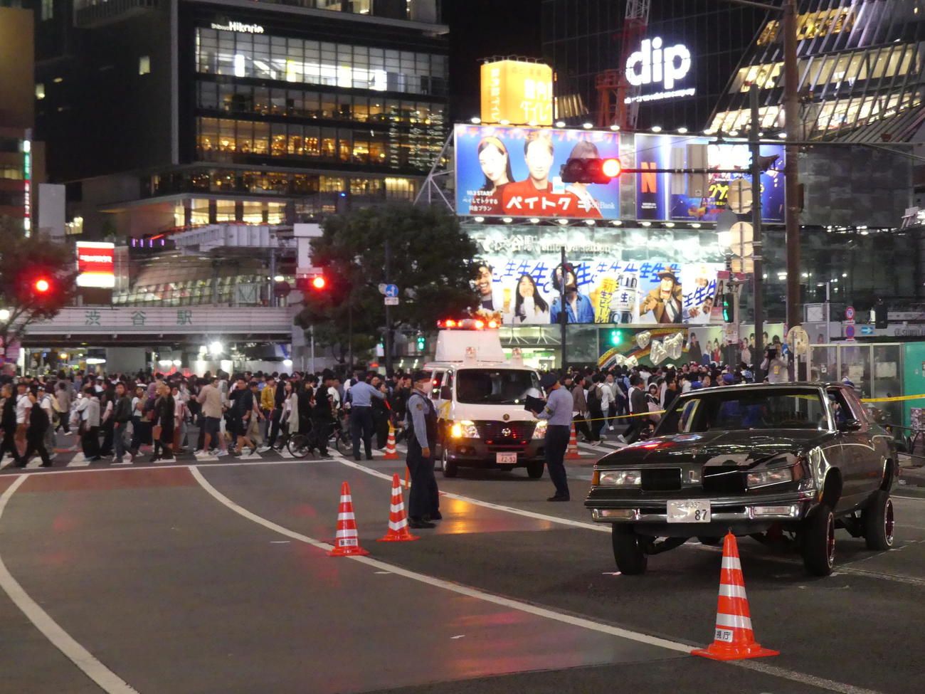 スクランブル交差点付近を横断する人々の近くで、事故を起こし大破して停車した乗用車（撮影・中山知子）