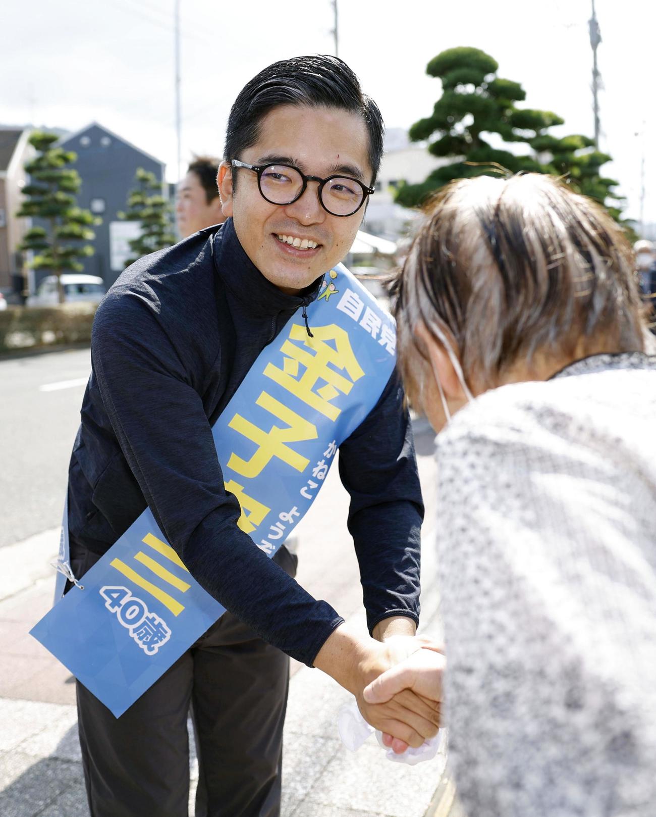 衆院長崎4区の補欠選挙が告示され、集まった人と握手する金子容三氏（共同）