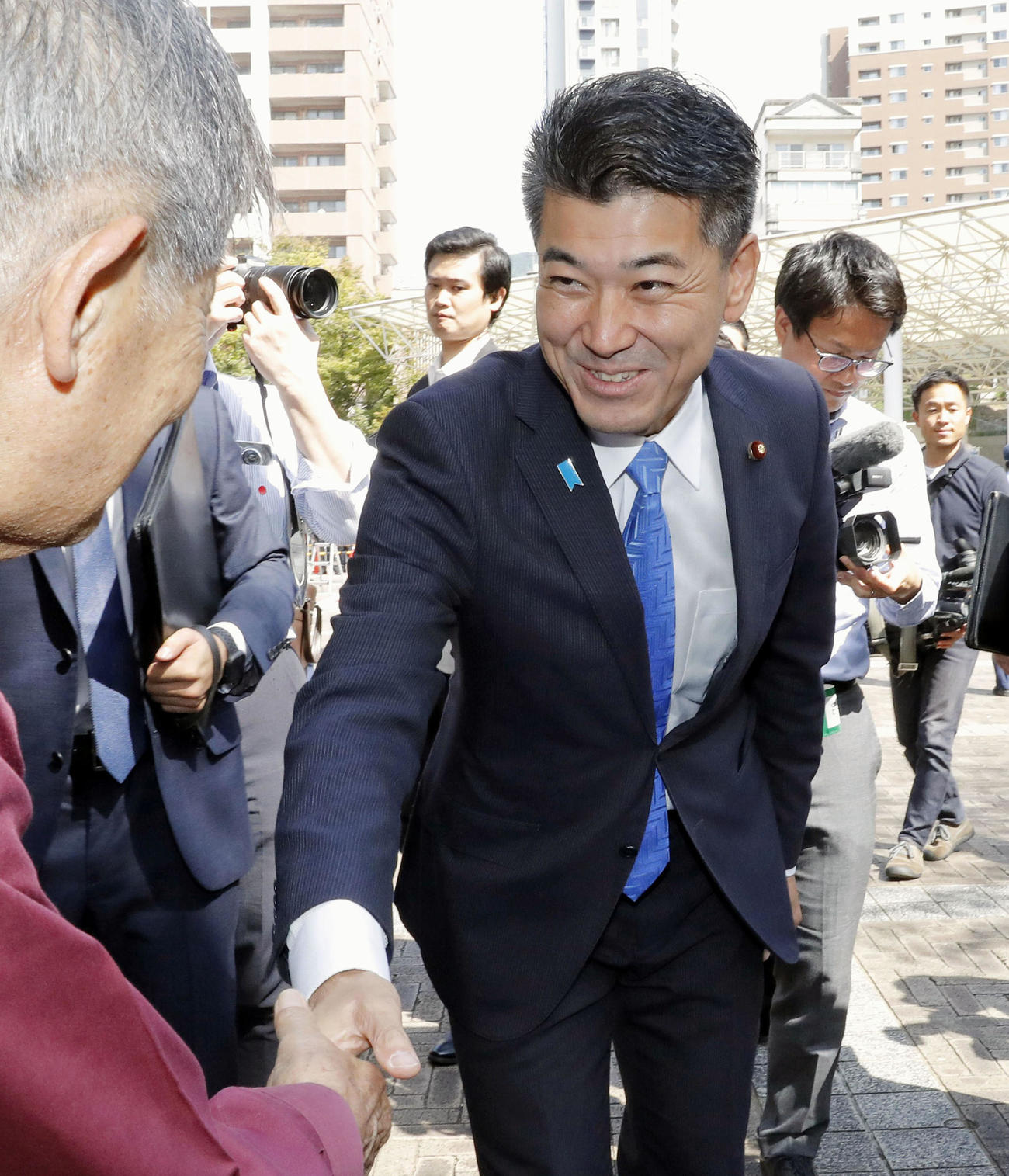 衆院長崎4区の補欠選挙が告示され、候補者の街頭演説に集まった人と握手する立憲民主党の泉代表（共同）