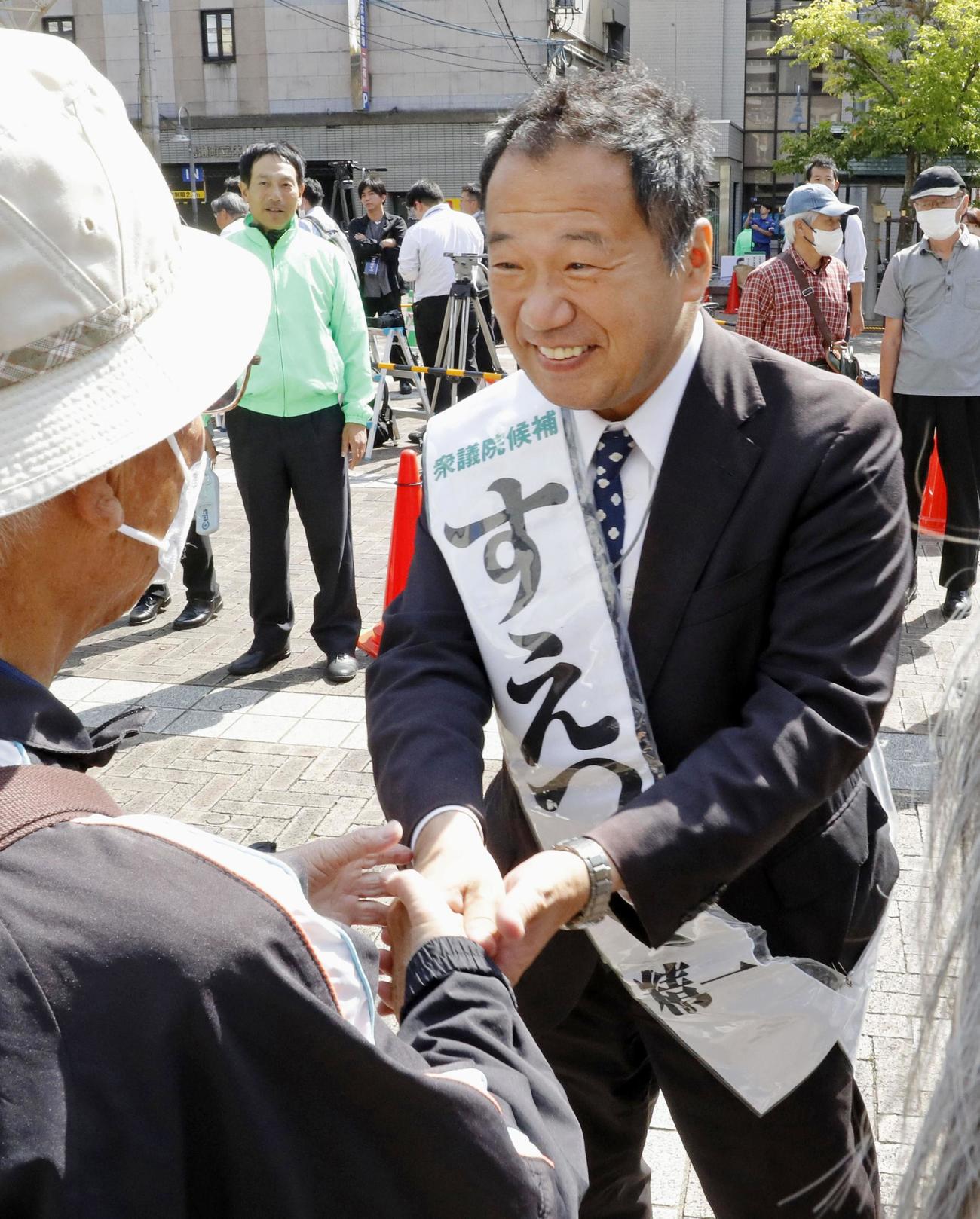 衆院長崎4区の補欠選挙が告示され、集まった人と握手する末次精一氏（共同）