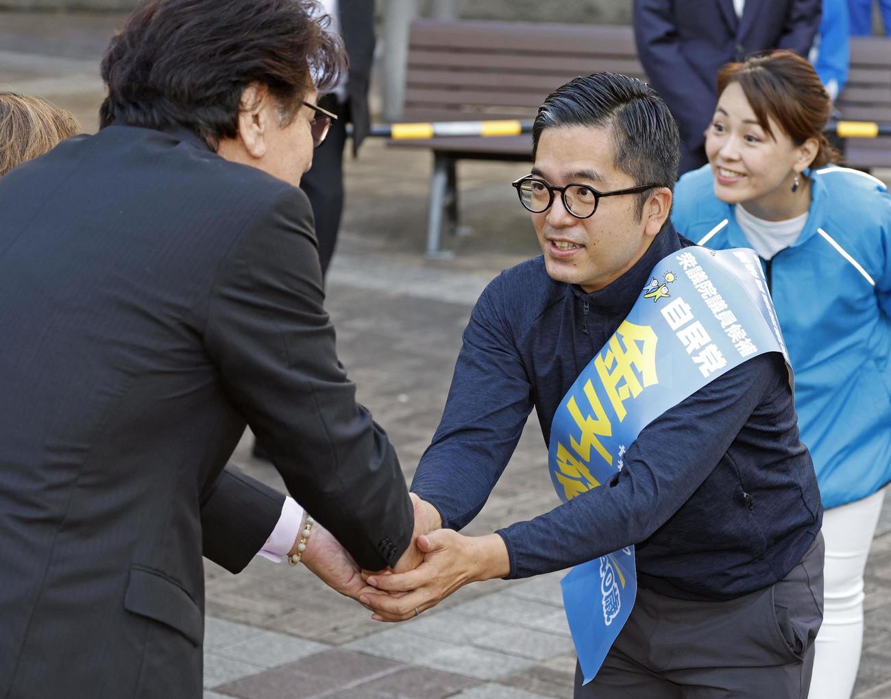 衆院長崎4区の補欠選挙が告示され、集まった人と握手する金子容三氏（右）（共同）