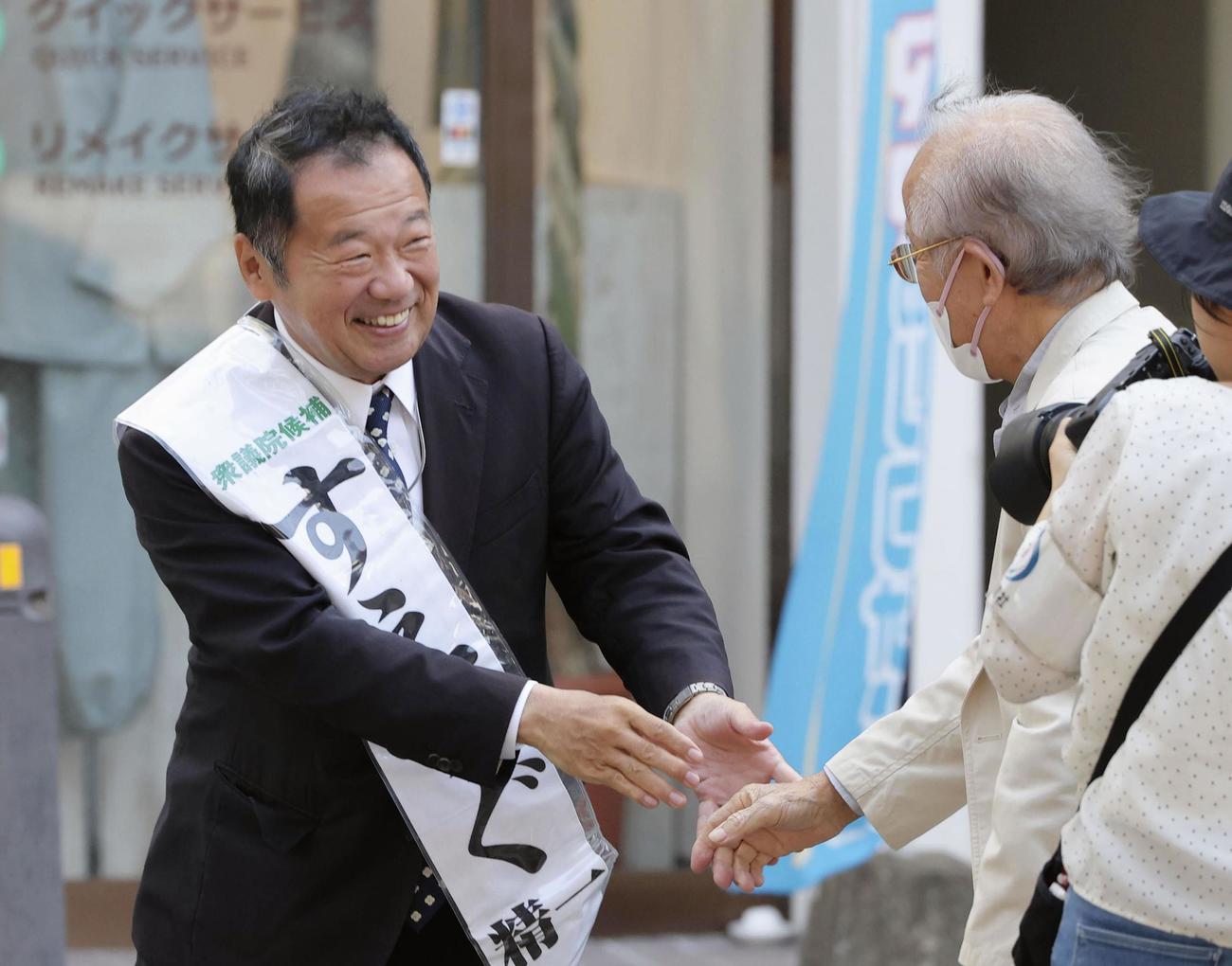 衆院長崎4区の補欠選挙が告示され、集まった人と握手する末次精一氏（左）（共同）