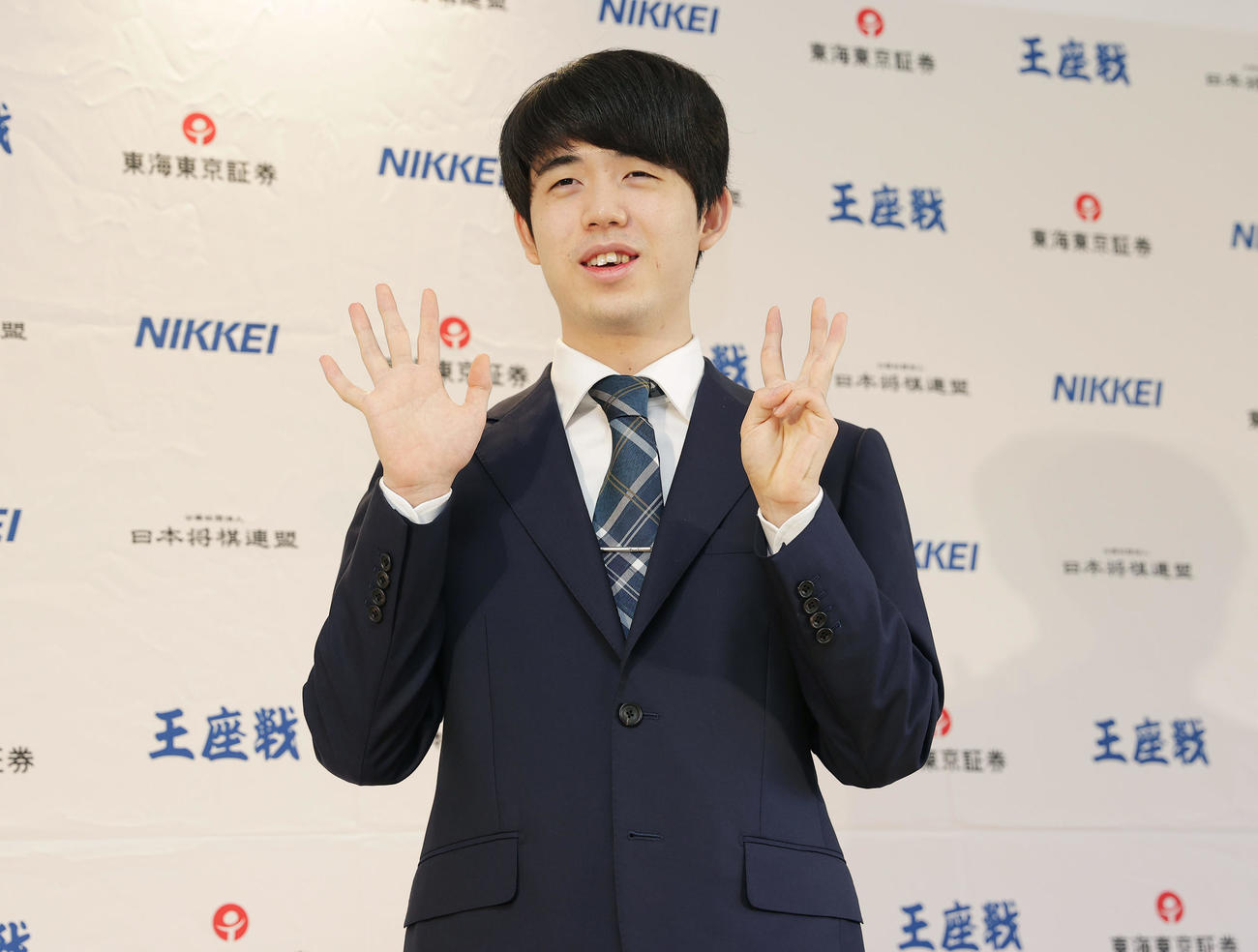偉業達成から一夜明け、笑顔で「8」のポーズをとる藤井8冠（撮影・前田充）