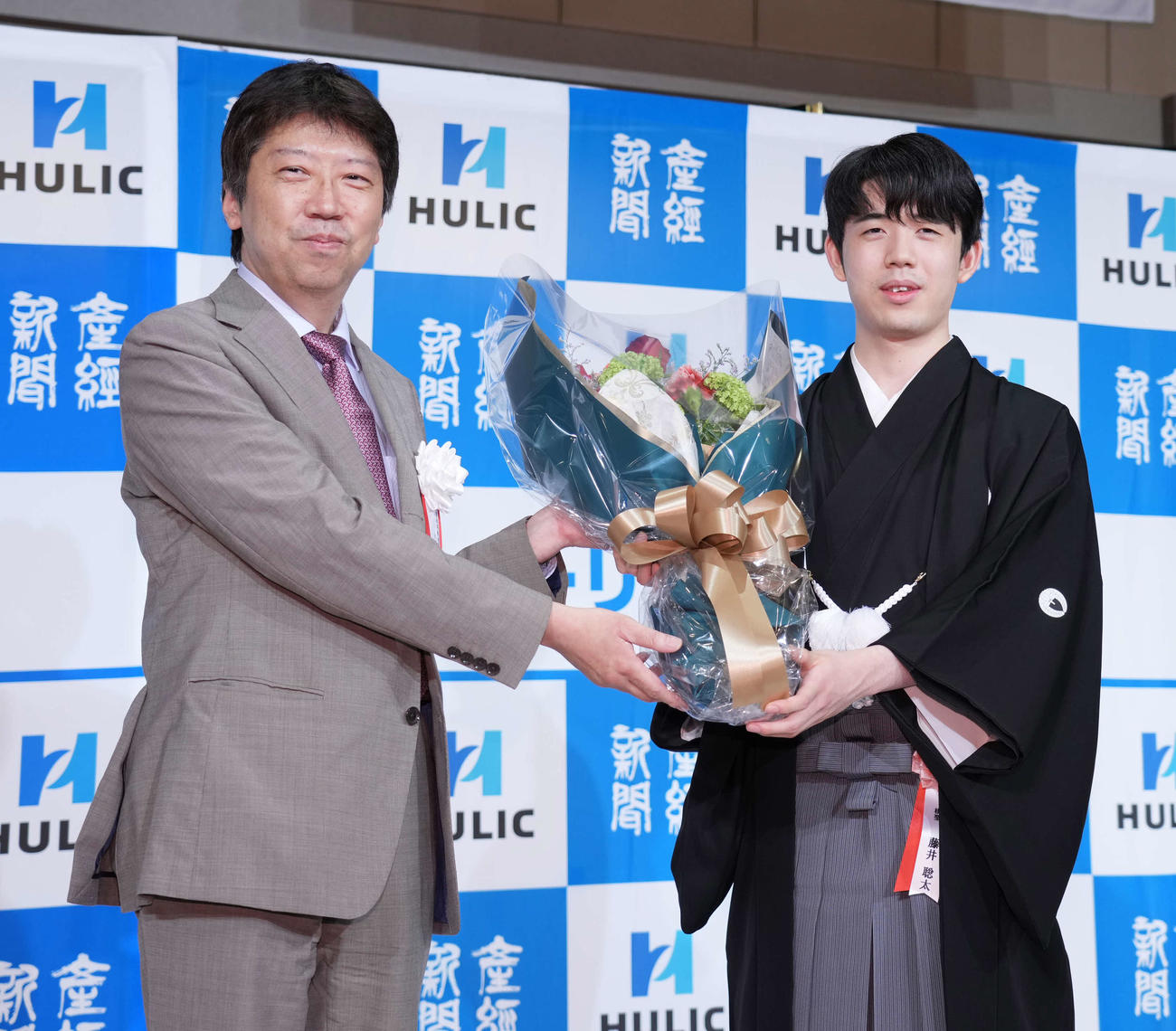 第94期ヒューリック杯棋聖就位式で師匠の杉本八段（左）から花束贈呈を受ける藤井棋聖（2023年10月撮影）