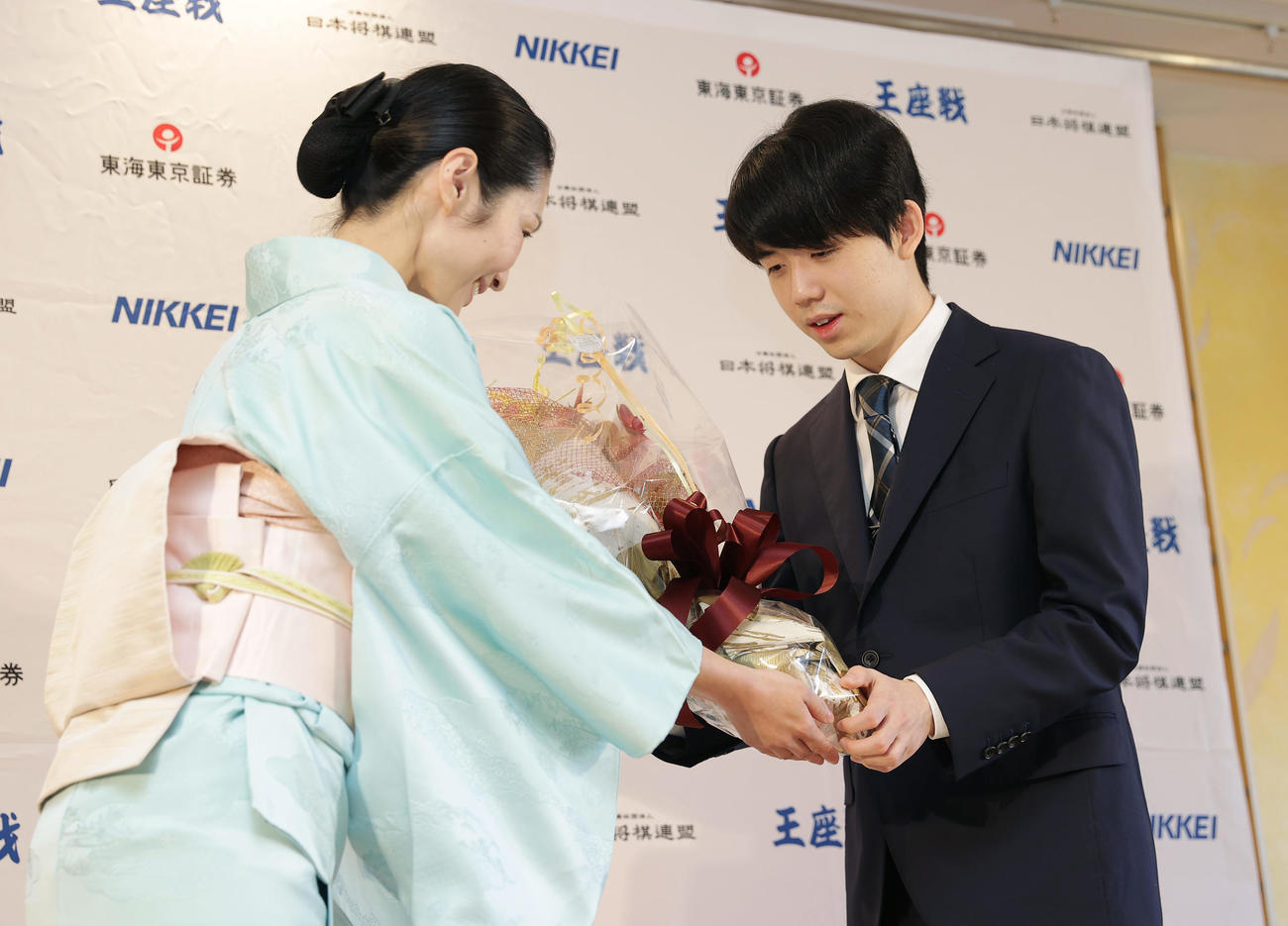 偉業達成から一夜明け、花束を受け取る藤井8冠（右）（撮影・前田充）