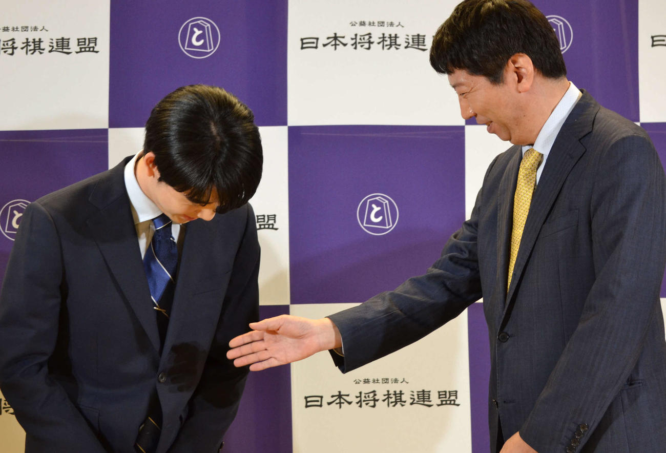 藤井聡太8冠（左）は師匠の杉本昌隆八段（右）から握手を求められる