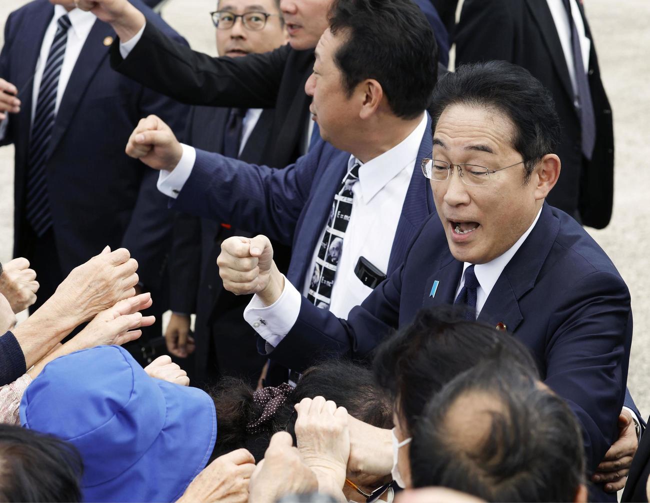 街頭演説を終え、集まった人たちとタッチを交わす自民党総裁の岸田首相（共同）
