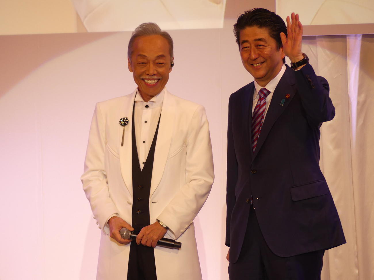 2018年3月の自民党大会にサプライズゲストで登場した時の谷村新司さん。右は当時の安倍晋三首相（2018年3月25日）