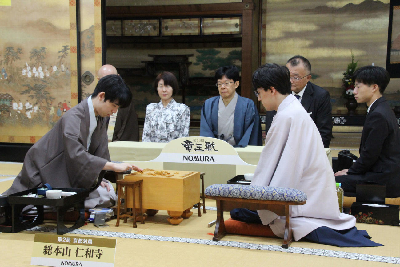 盤上に駒を並べる藤井聡太8冠（左）伊藤匠七段（日本将棋連盟提供）