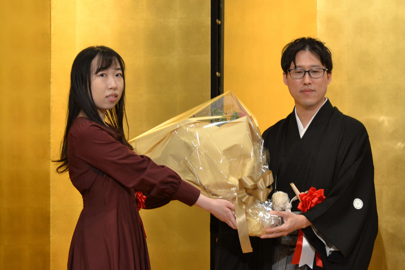 第48期碁聖就位式で茂呂有紗二段（左）から花肌を贈呈される井山裕太碁聖（右）