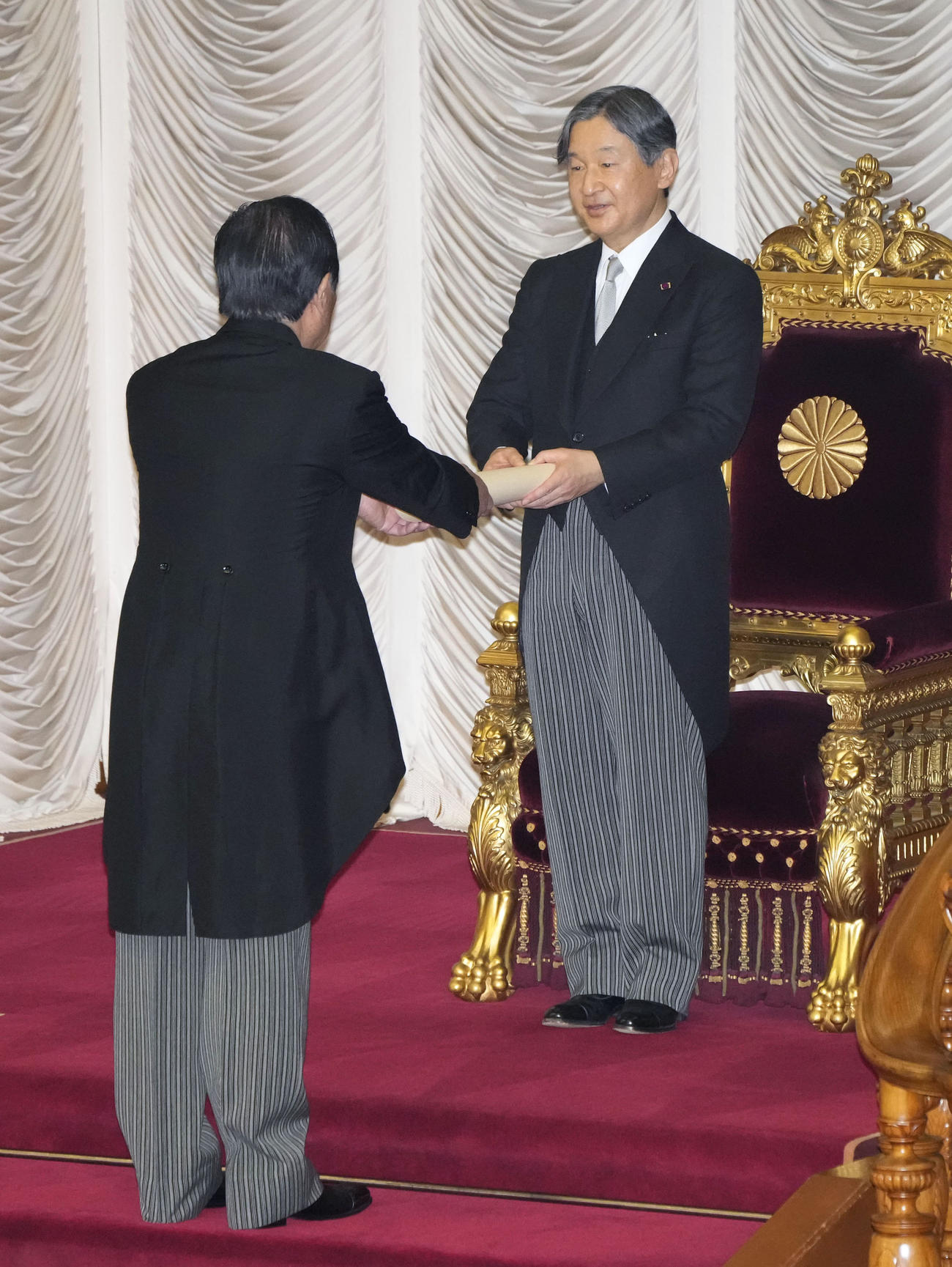 第212臨時国会の開会式で、額賀衆院議長から式辞を受け取られる天皇陛下＝20日午後、参院本会議場（共同）