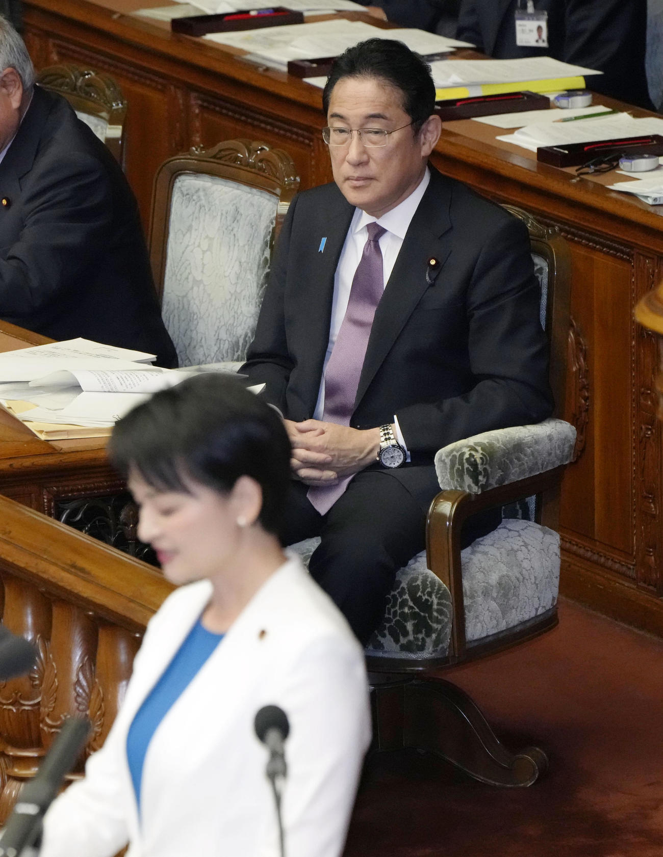 衆院本会議で立憲民主党の吉田晴美氏（手前）の質問を聞く岸田首相（共同）