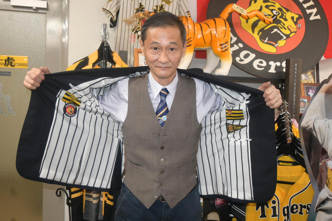 裏地に阪神のユニホームを模した縦じまのブレザーを着る「テーラー虎」の中村英二店長（撮影・松浦隆司）