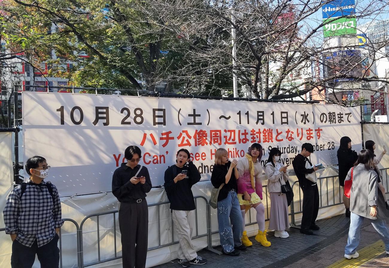 ハロウィーン期間に入り、渋谷駅前のハチ公像は白い幕で囲われたが、普段と変わらず観光客など多くの人が待ち合わせなどで集まっていた