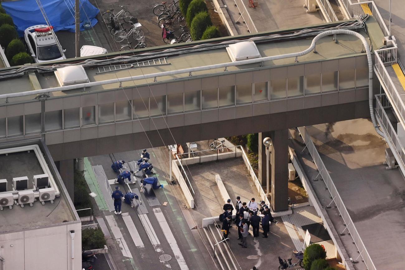 発砲したような大きな音があった戸田中央総合病院の現場周辺を調べる捜査員（共同通信社ヘリから）