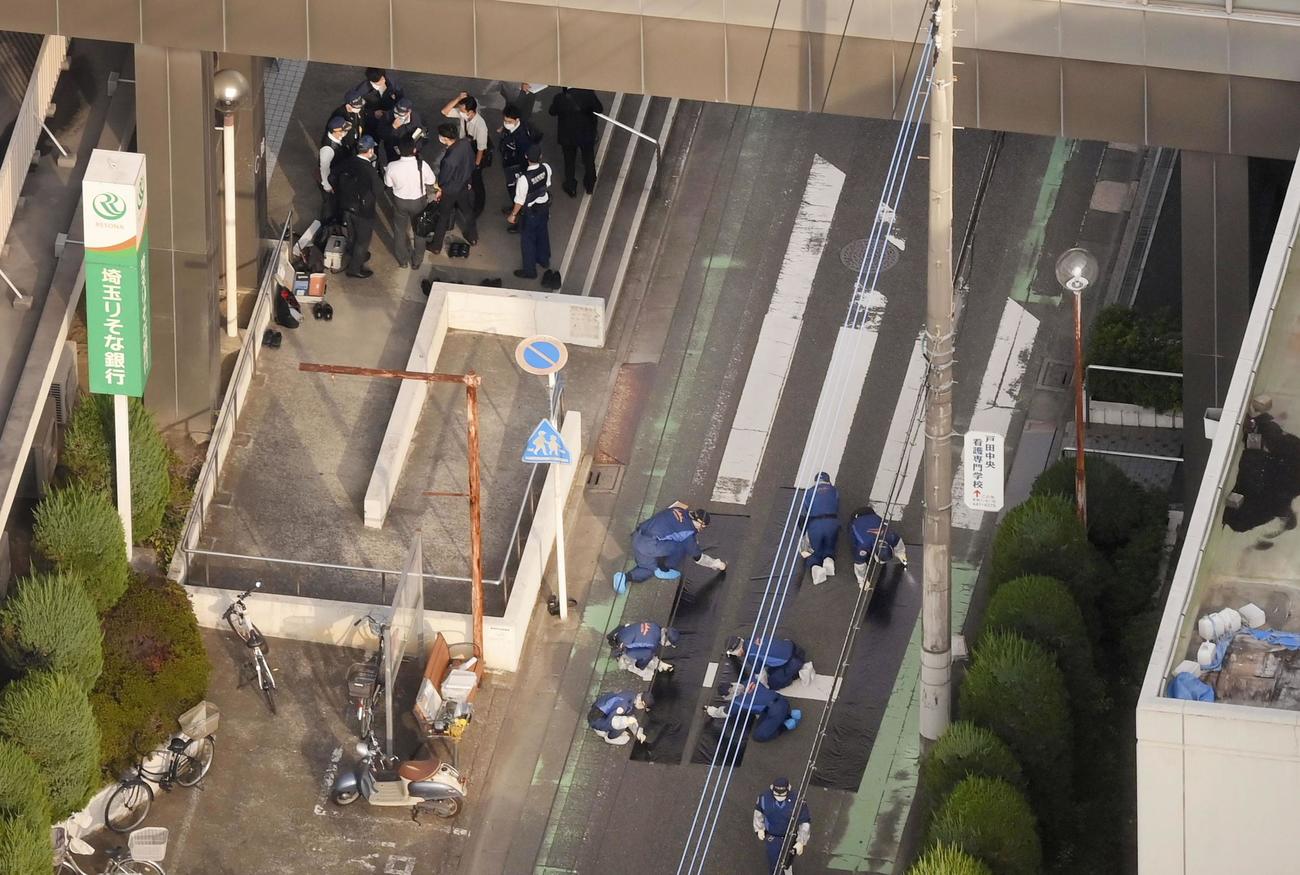 発砲したような大きな音があった戸田中央総合病院の現場周辺を調べる捜査員（共同通信社ヘリから）