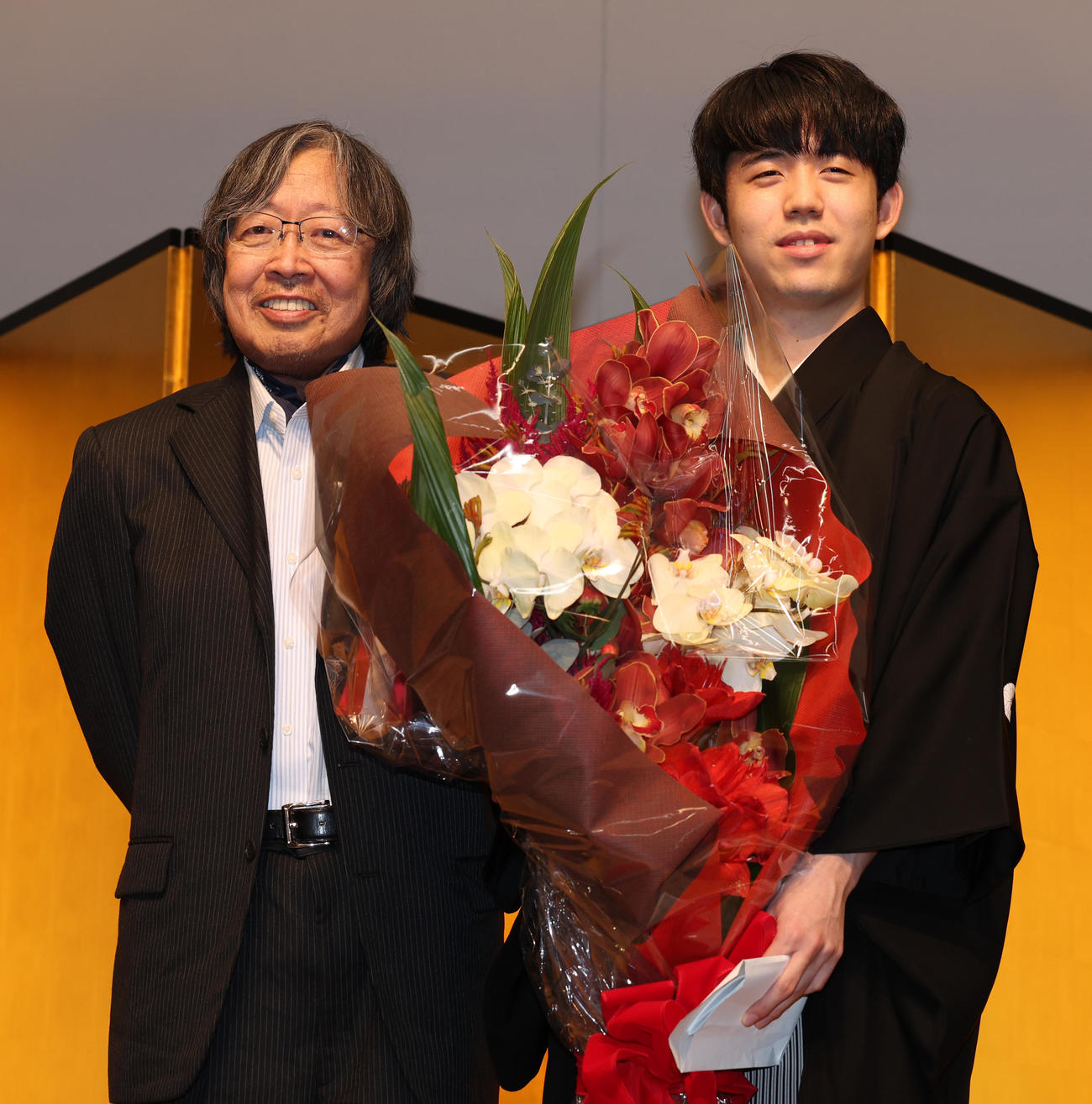 大崎善生氏（左）から花束を受けとる藤井王位（撮影・野上伸悟）