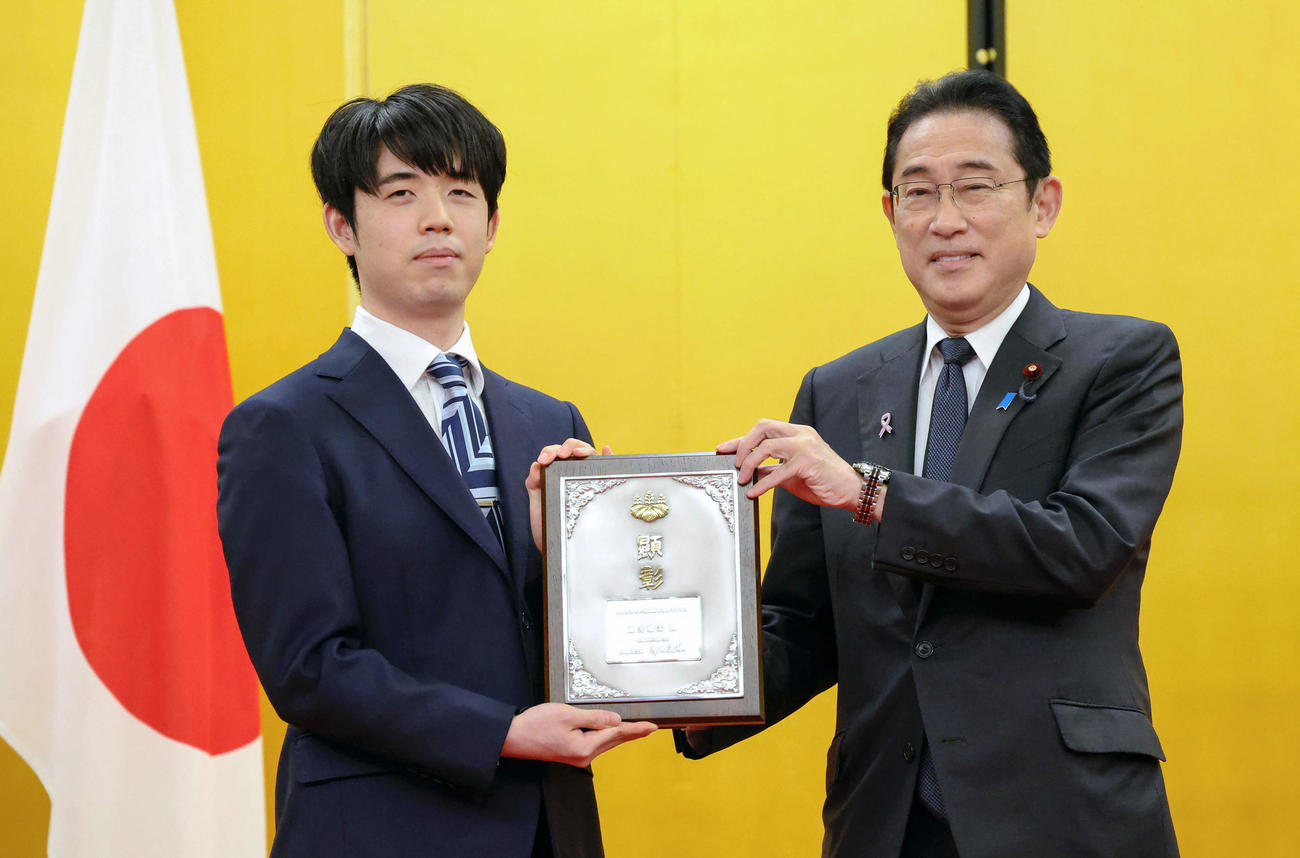 岸田首相から内閣総理大臣顕彰の盾を贈られる将棋の藤井聡太八冠（左）（代表撮影）