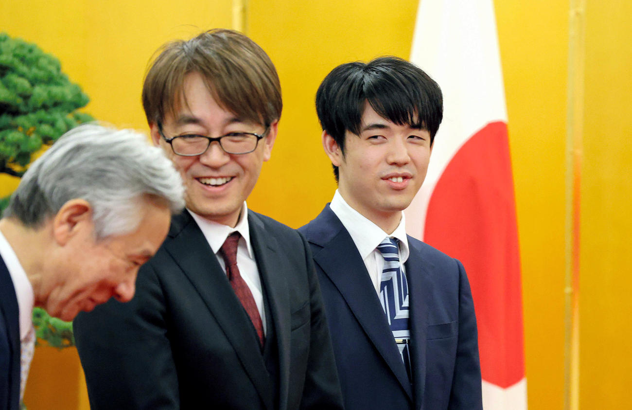 内閣総理大臣顕彰式に臨む将棋の藤井聡太八冠（右）。中央は日本将棋連盟会長の羽生善治さん（代表撮影）