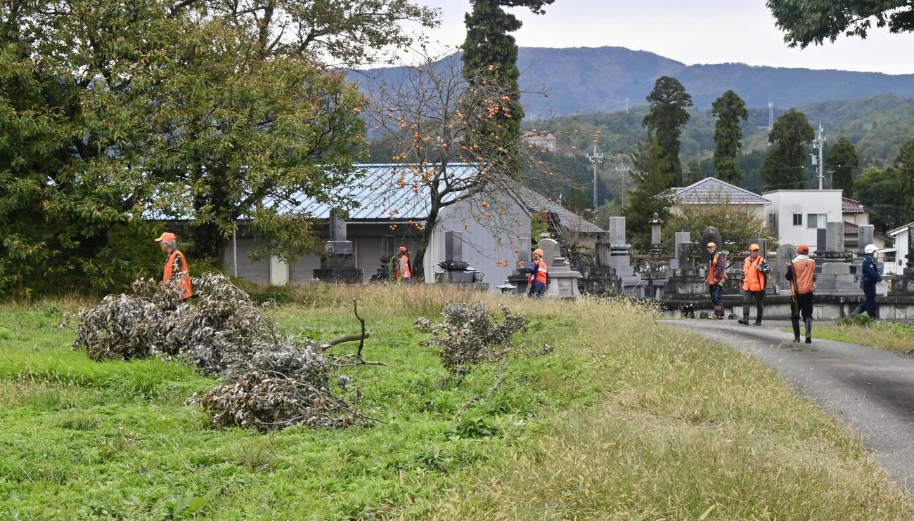 クマが逃げ込んだ場所付近で警戒する猟友会の会員ら＝16日午後、富山市上今町（共同）