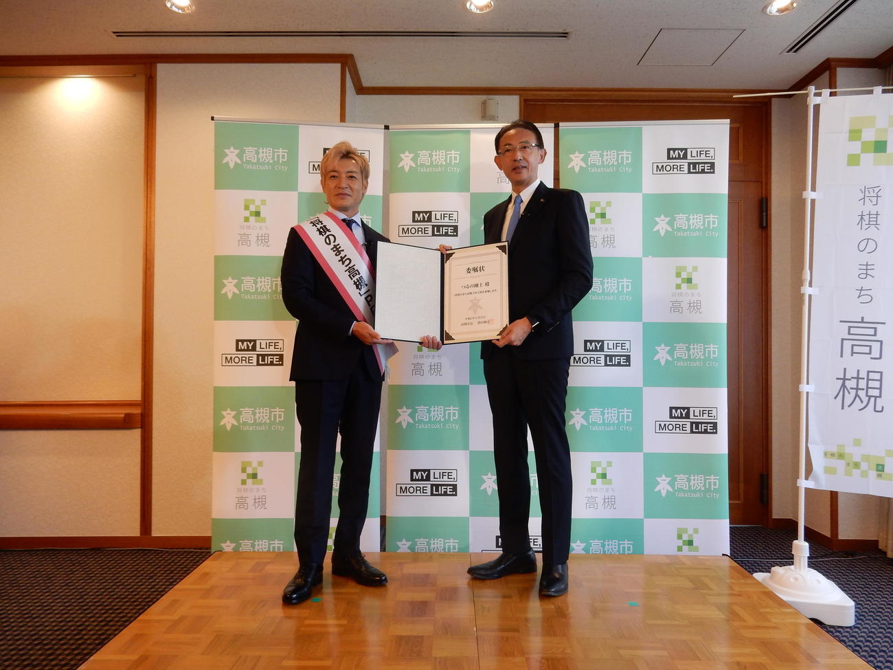 大阪府高槻市の「将棋のまち高槻」PR大使に就任したつるの剛士（左）、委嘱状を手渡す高槻市の濱田剛史市長