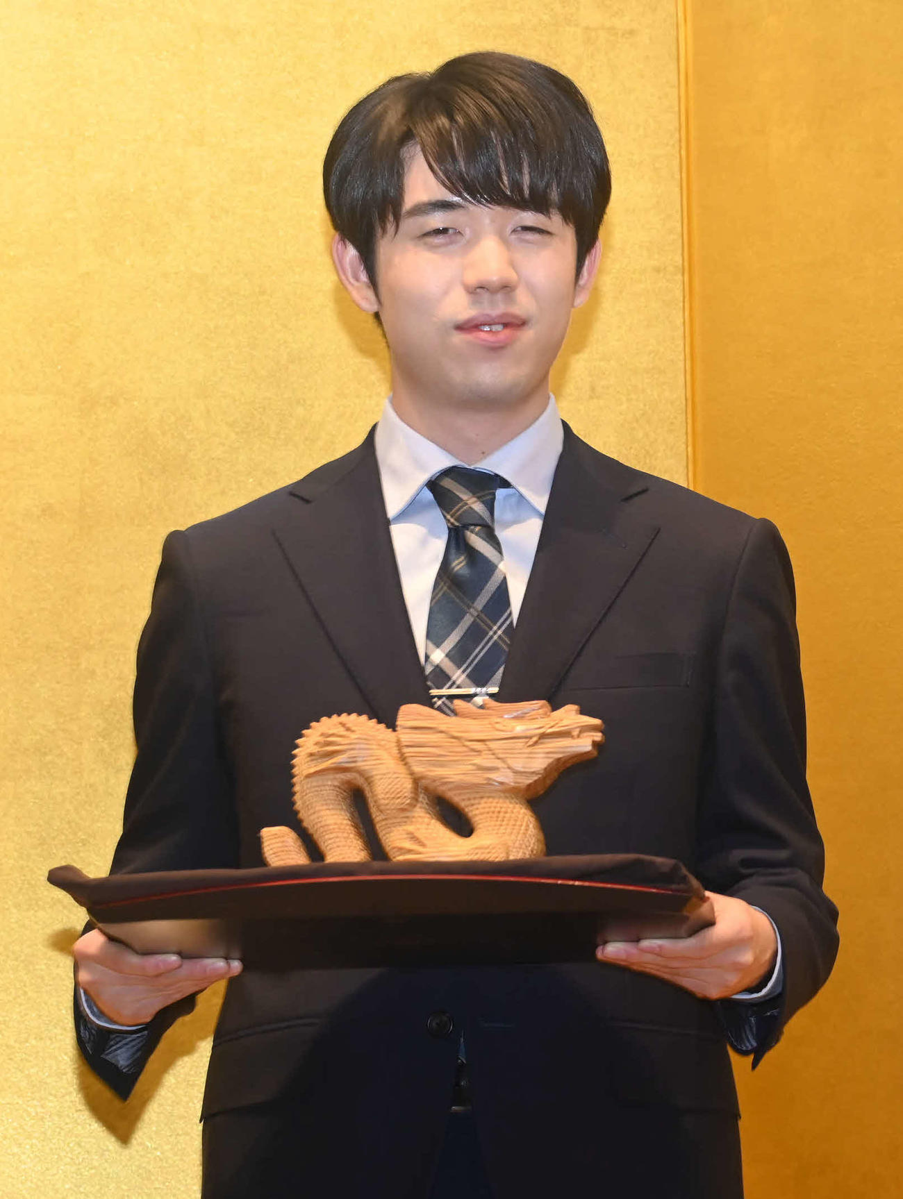 記念品として龍の置物を手渡された藤井聡太竜王（撮影・松浦隆司）