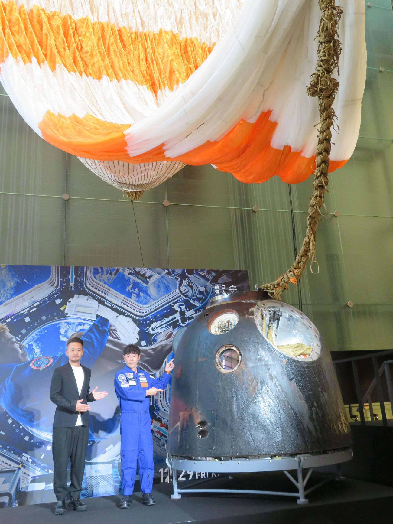 ドキュメンタリー映画「僕が宇宙に行った理由」公開を記念した特別展で日本初展示された、ソユーズの帰還モジュールを横に、笑顔の平野陽三監督（左）と前澤友作氏（撮影・村上幸将）