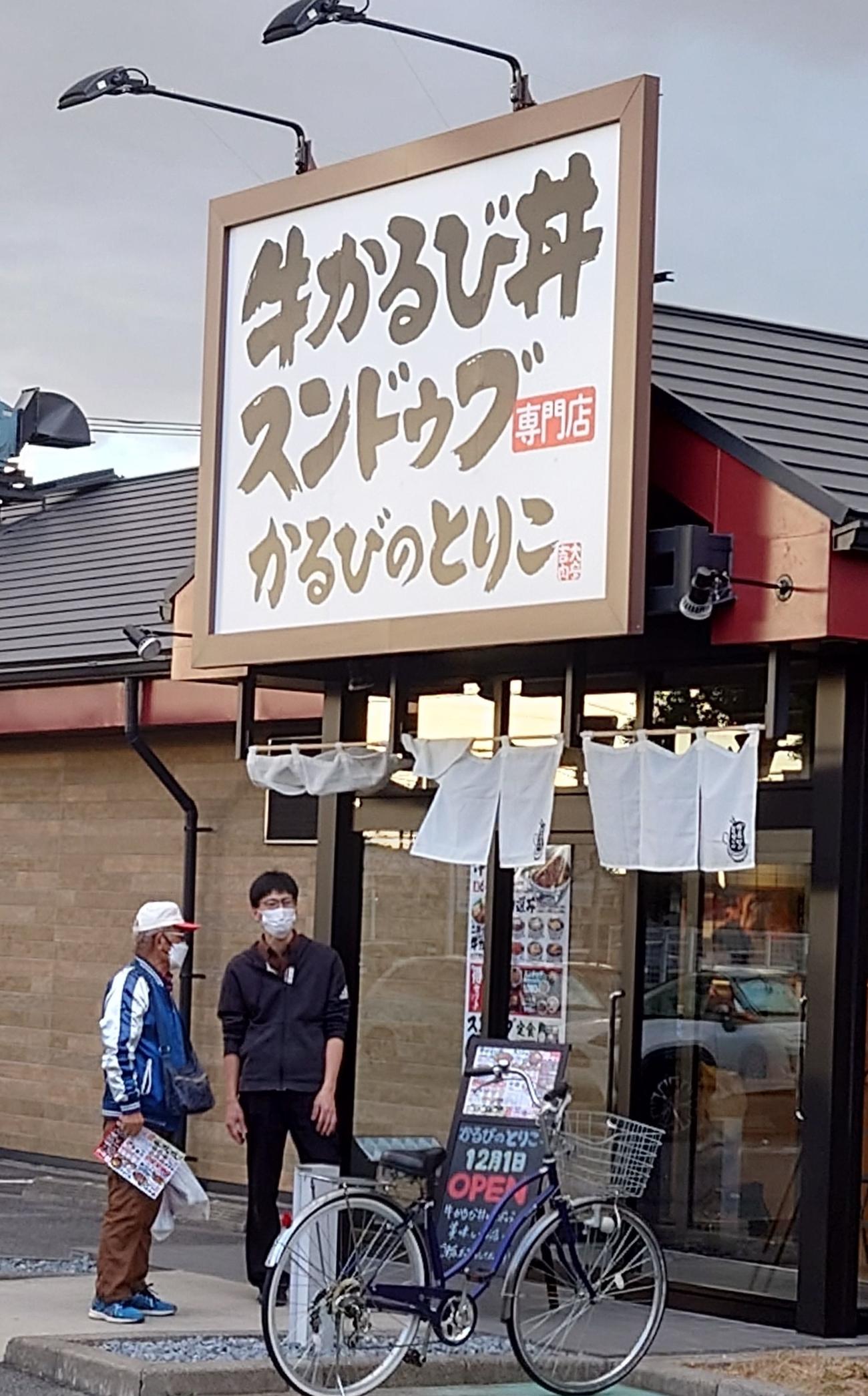 12月1日の開店を控えて、通行人の男声と店員がなごやかに会話していた（撮影・寺沢卓）