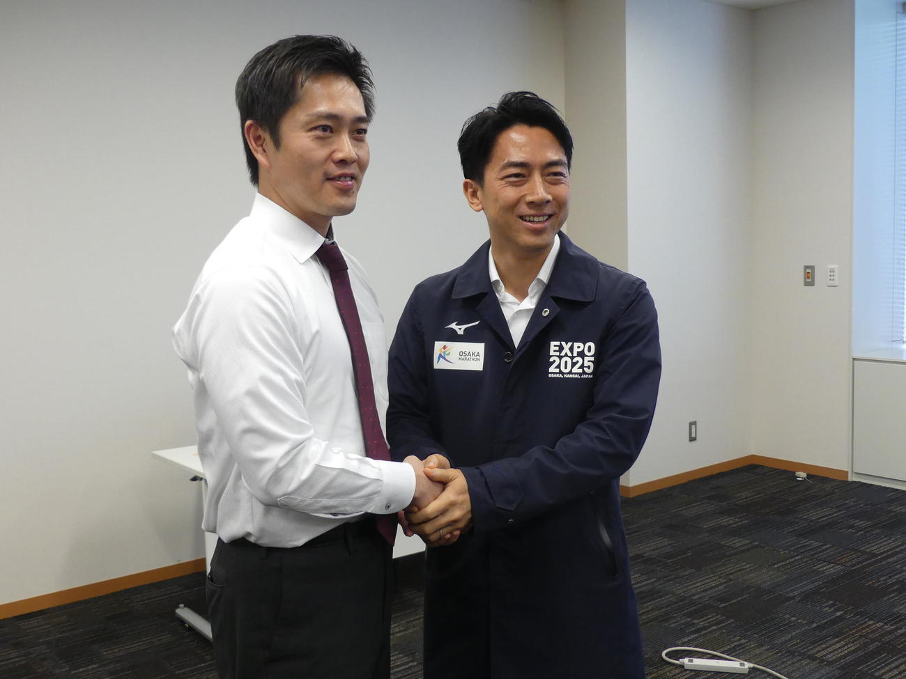 吉村洋文知事（左）の万博ブルゾンを着せてもらい握手を交わす小泉進次郎元環境相（撮影・中山知子）