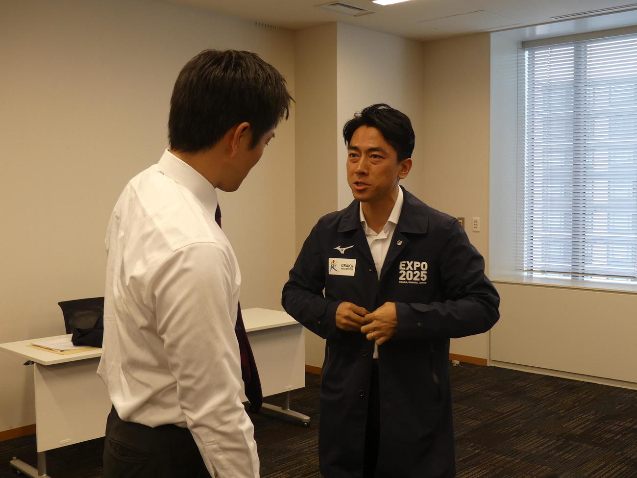 吉村洋文知事（左）が着ていた大阪万博のブルゾンを勧められ着用する小泉進次郎元環境相（撮影・中山知子）