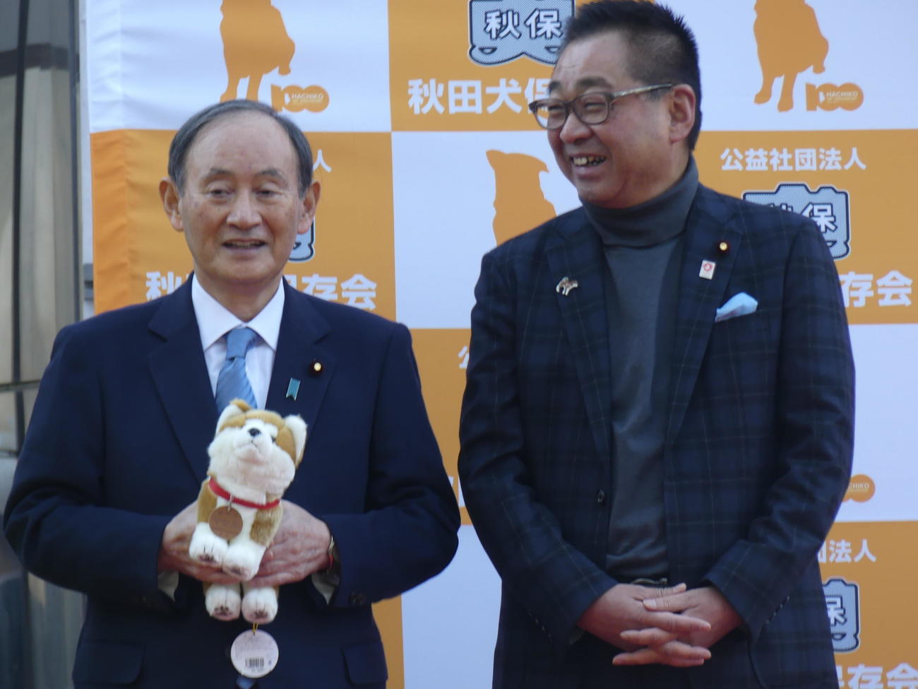 秋田犬保存会会長の日本維新の会の遠藤敬衆院議員（右）と談笑する菅義偉前首相（撮影・中山知子）