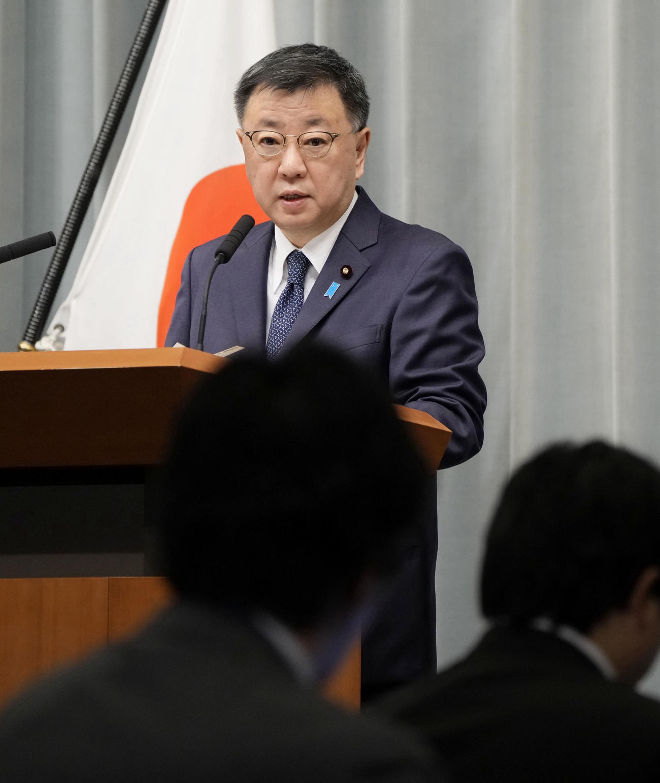 記者会見する松野官房長官（共同）