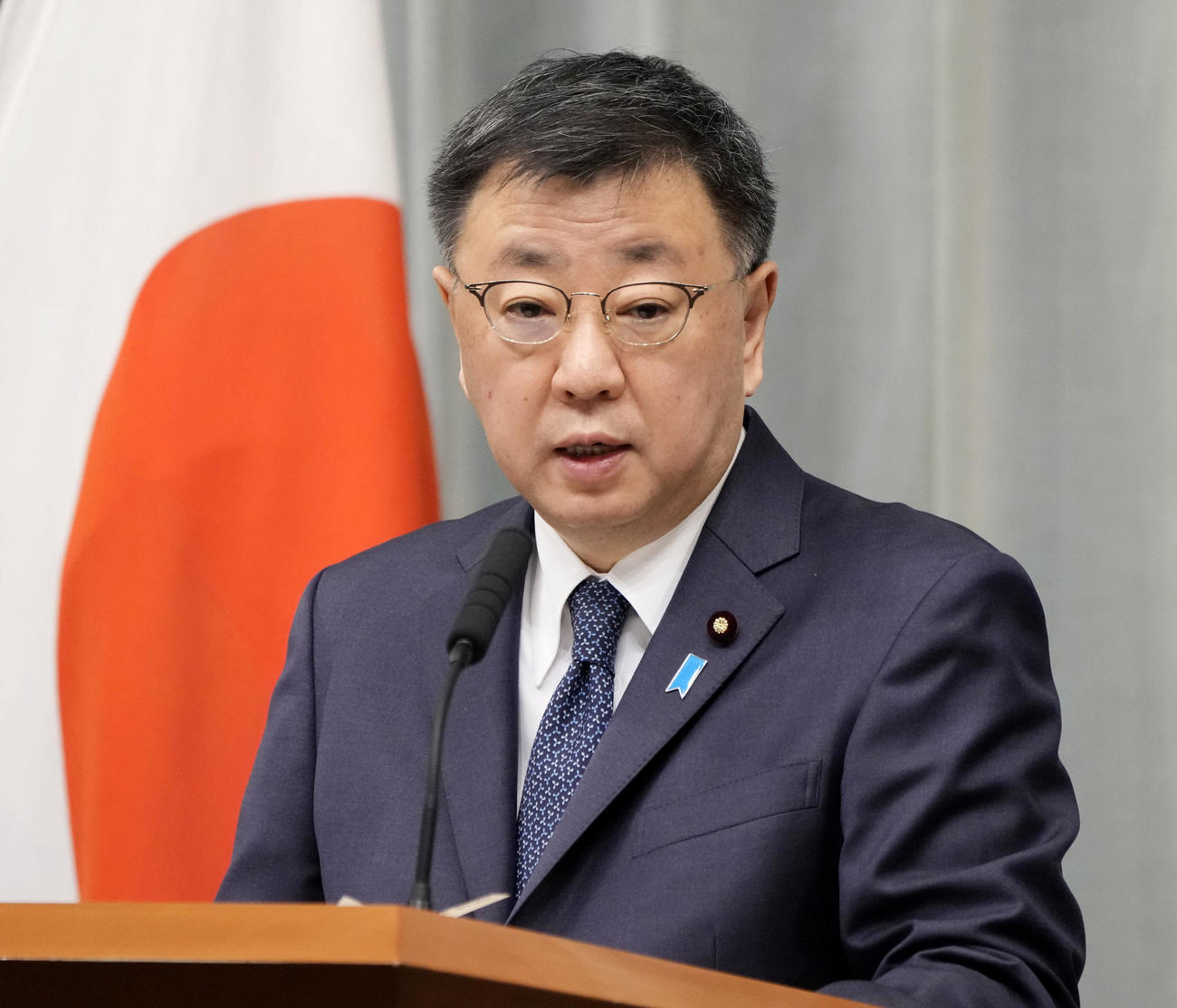 記者会見する松野官房長官（共同）