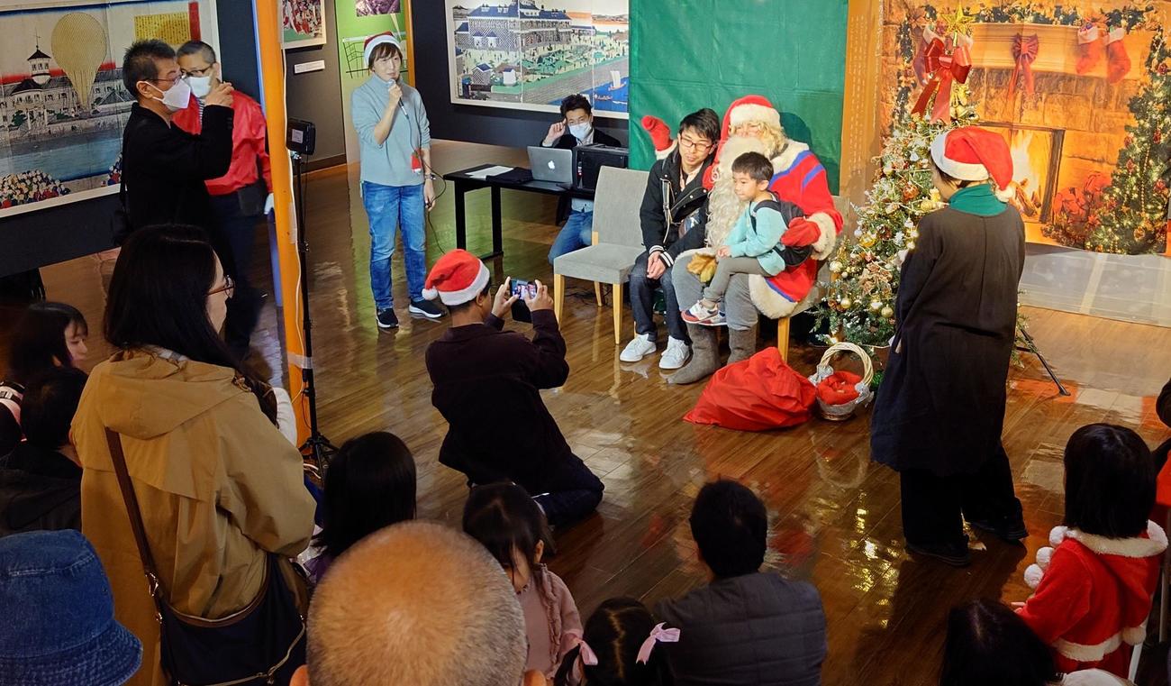 当日募集のサンタさんの撮影会だったが、多くの家族連れに囲まれた（撮影・寺沢卓）