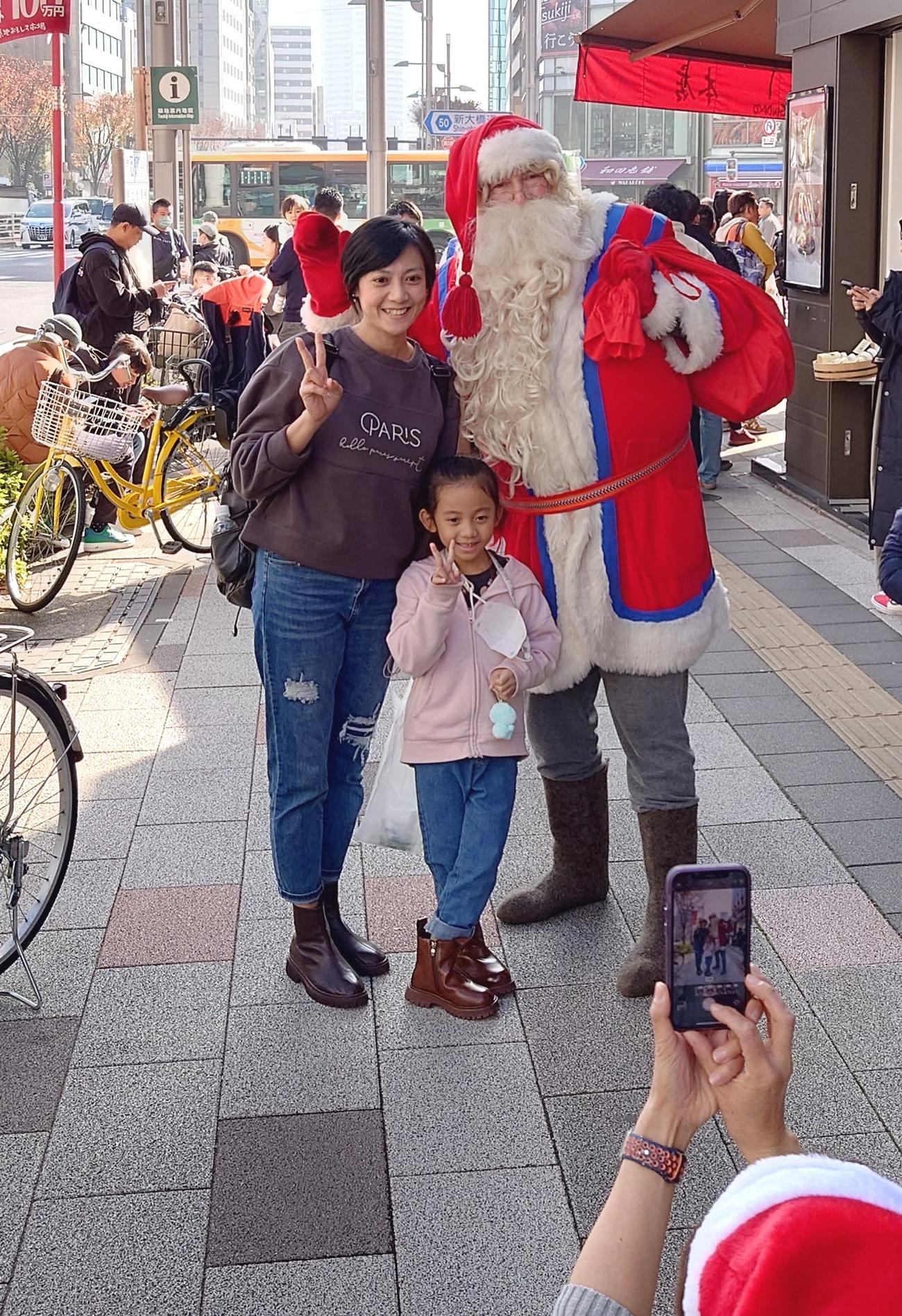土曜の築地場外を歩くだけでサンタさんの周囲に人が集まってきた（撮影・寺沢卓）