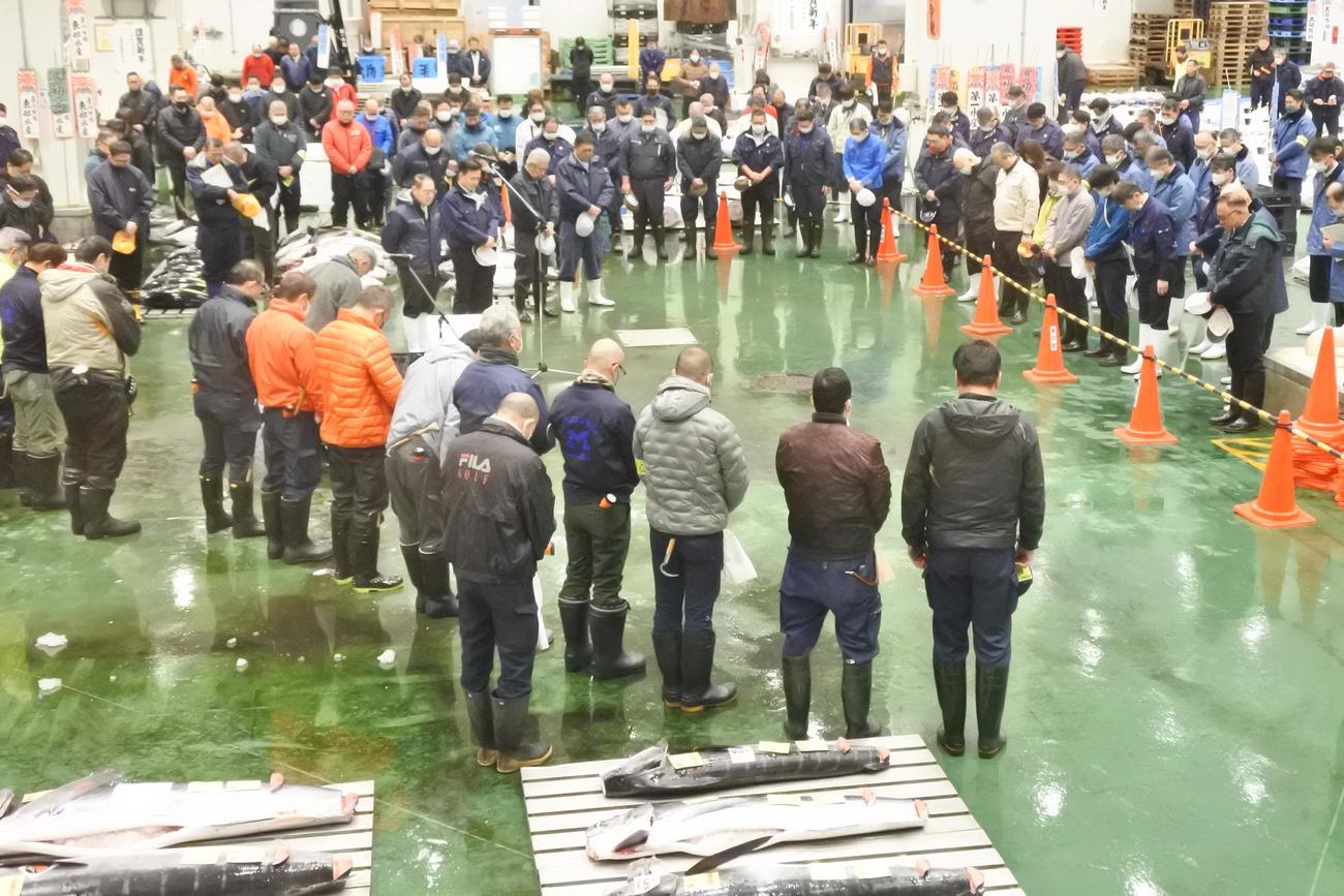 初競り前の新年あいさつで能登半島地震の犠牲者に黙祷を捧げる仲買人ら豊洲市場の関係者（撮影・中島正好）
