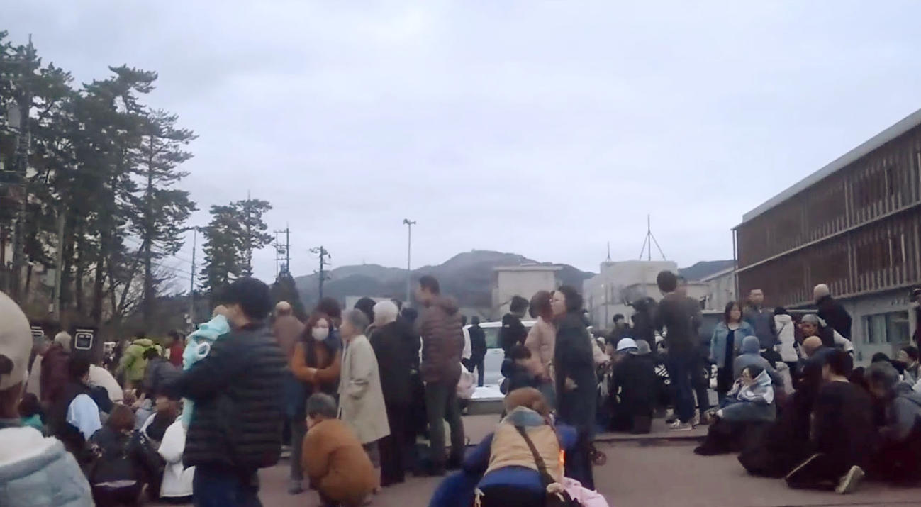 強い揺れの後、高台にある中学校の駐車場に避難した人たち＝1日午後5時ごろ、石川県輪島市（共同）