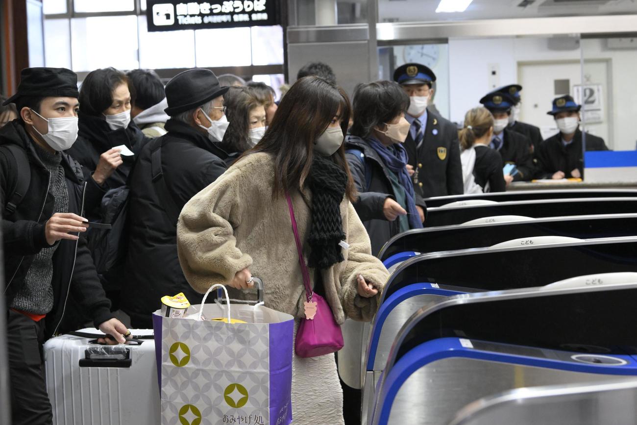 JR金沢駅で北陸新幹線の東京行き列車の運転再開予定がアナウンスされ、改札を通る乗客ら（共同）