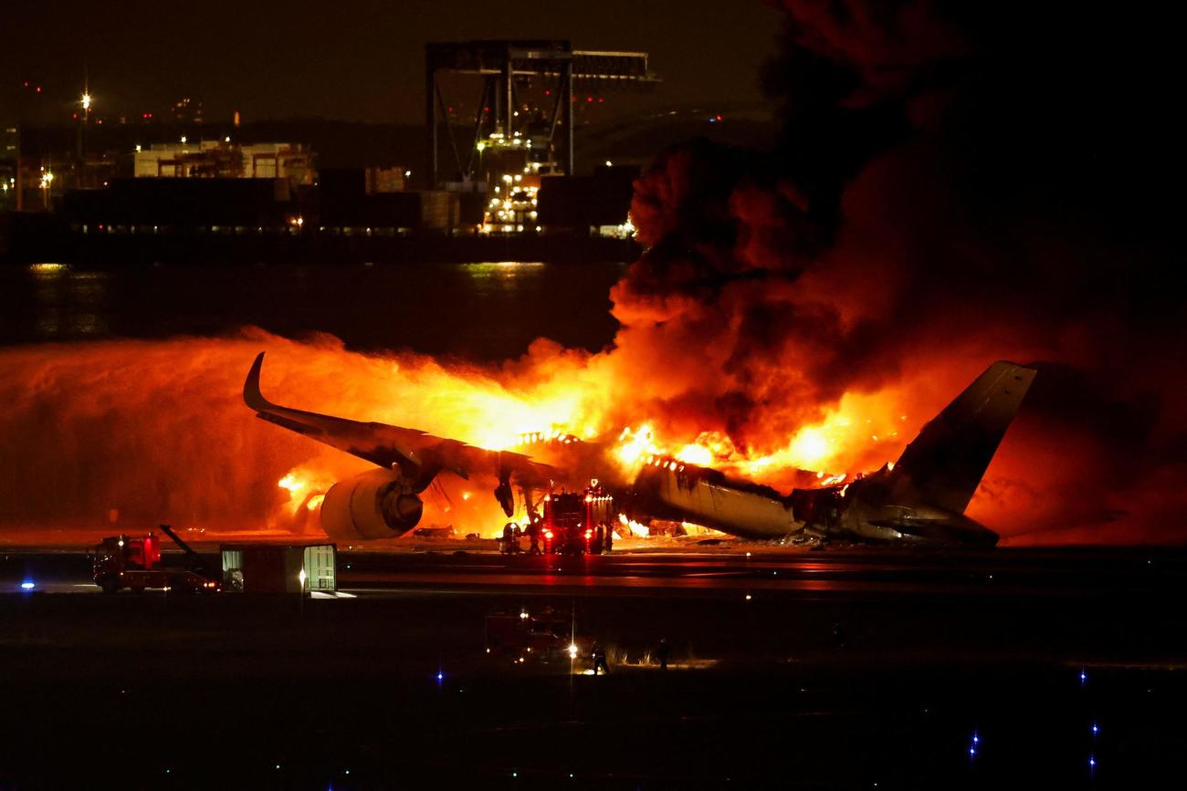 羽田空港のC滑走路で炎上する日航516便（ロイター）