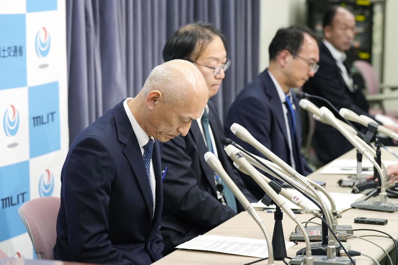 羽田空港での日航機と海上保安庁機の衝突事故を受け、記者会見で頭を下げる海上保安庁の瀬口良夫次長。奥は国交省の担当者（共同）