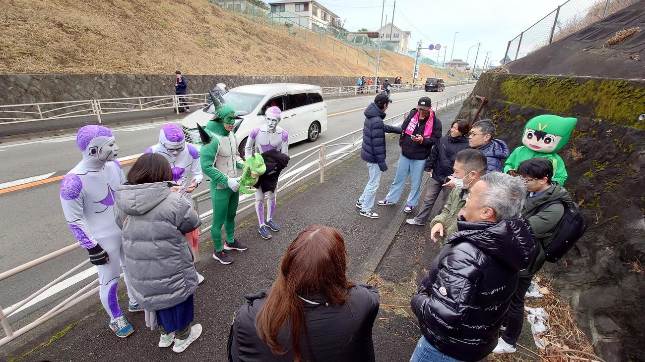 7区二宮町付近の沿道で配置につこうとしているフリーザ軍団を見つけた一般客が年始のあいさつをしていた（撮影・寺沢卓）