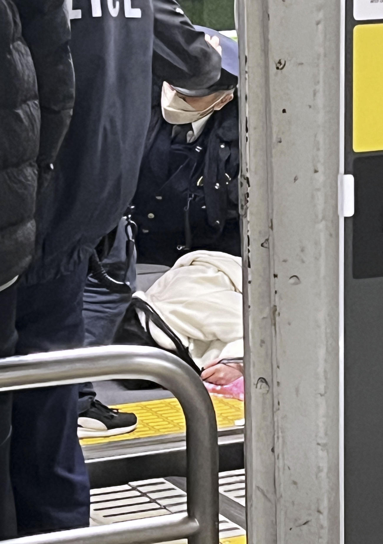 電車内で取り押さえられた容疑者とみられる女（中央）（目撃者提供）（共同）