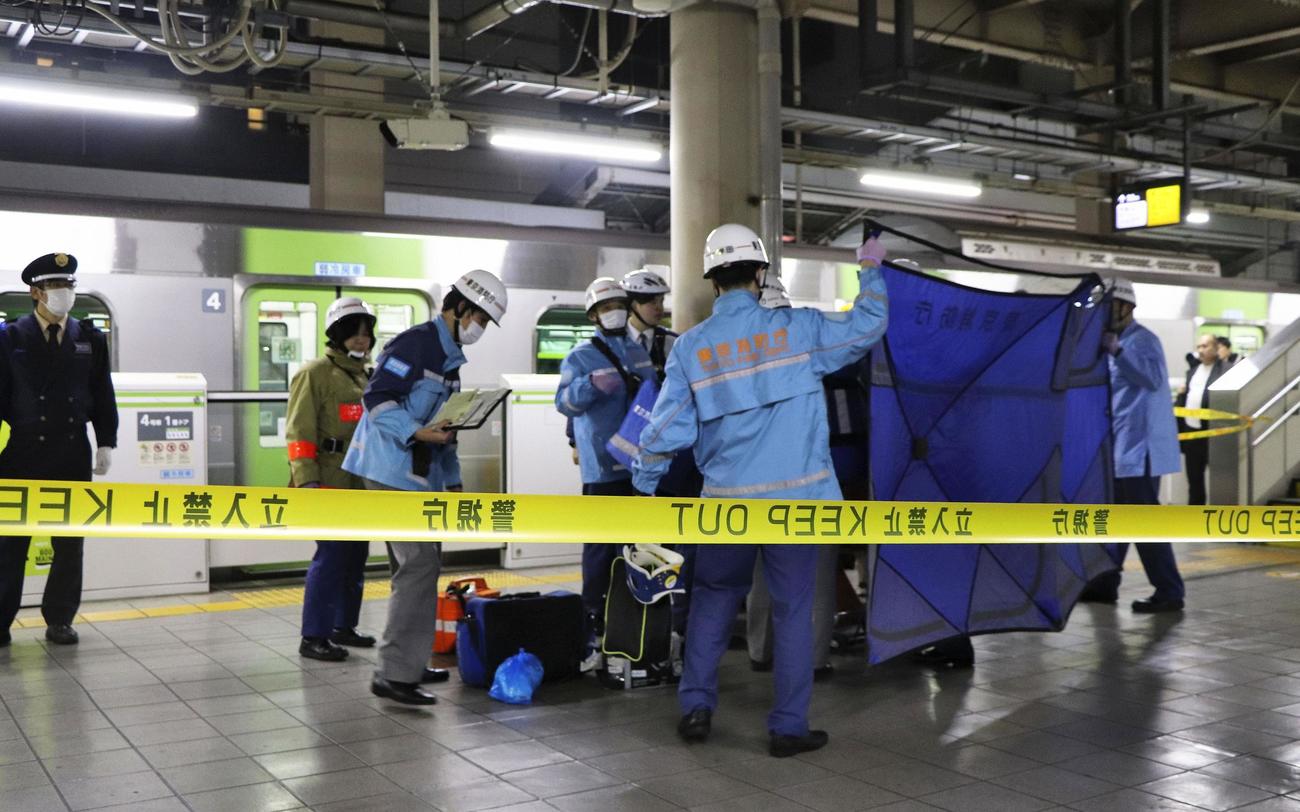JR秋葉原駅の山手線ホームで、刃物で切り付けられたとみられる人を搬送する消防隊員ら（共同）