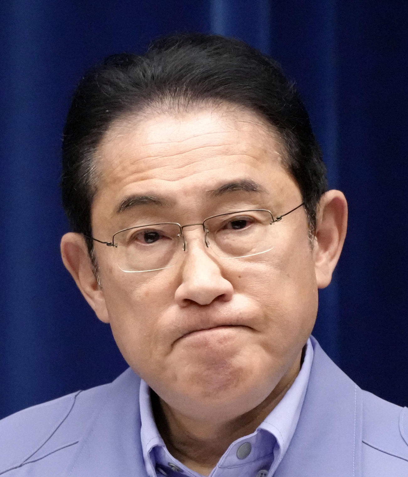 年頭の記者会見で、厳しい表情を見せる岸田首相（共同）