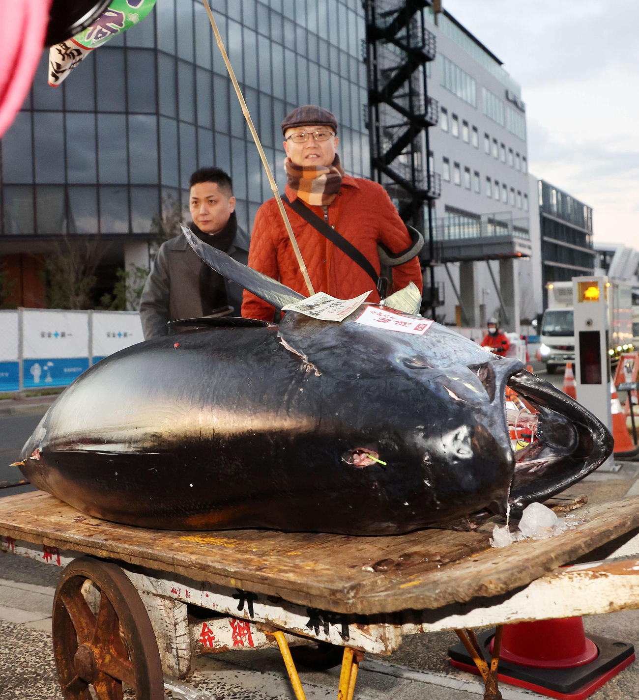初競り1番で落とされたマグロと市場を出てくる長尾社長（左）と坂上料理長（撮影・鈴木正人）