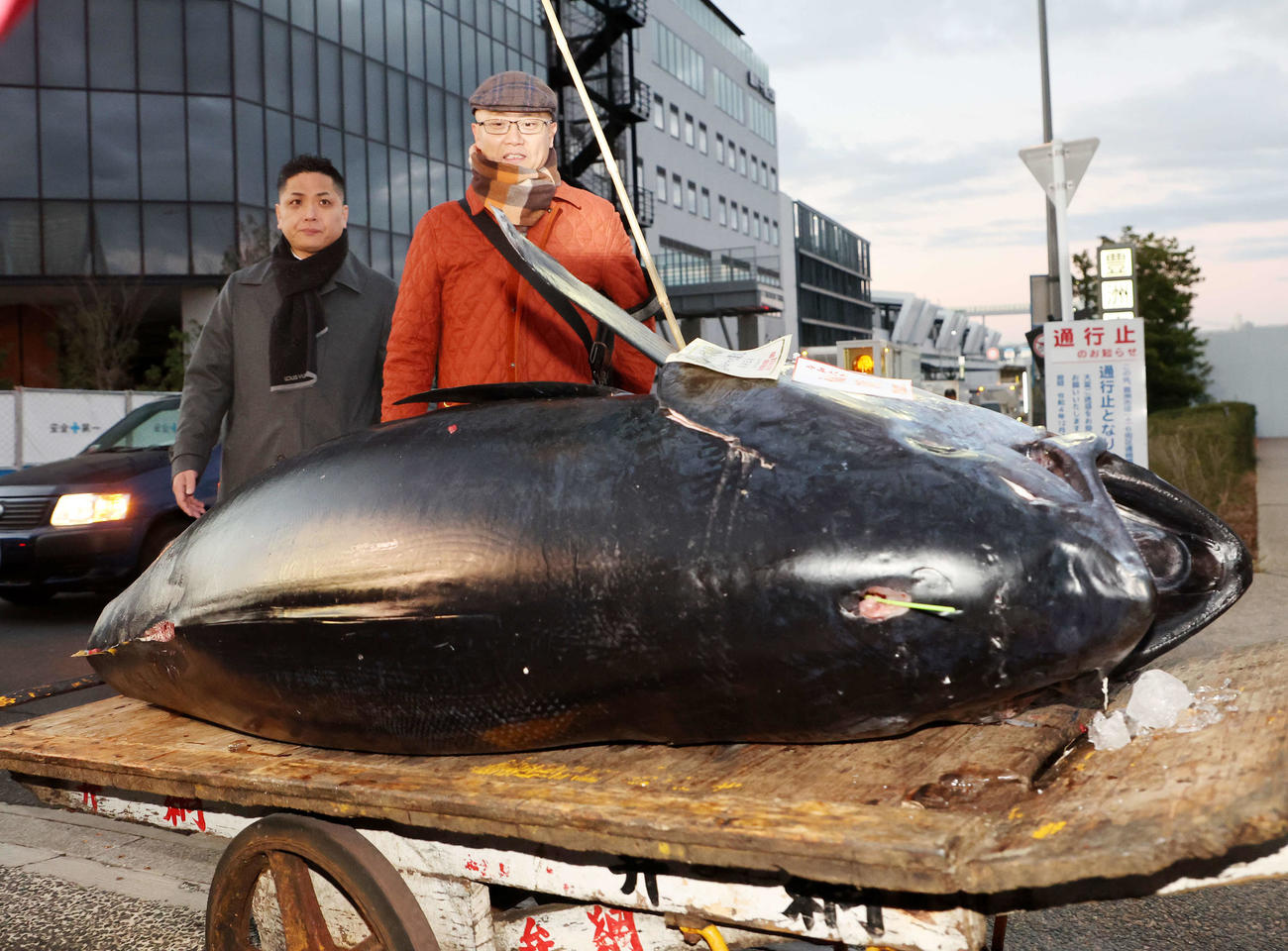 初競り1番で落とされたマグロと市場を出てくる長尾社長（左）と坂上料理長（撮影・鈴木正人）