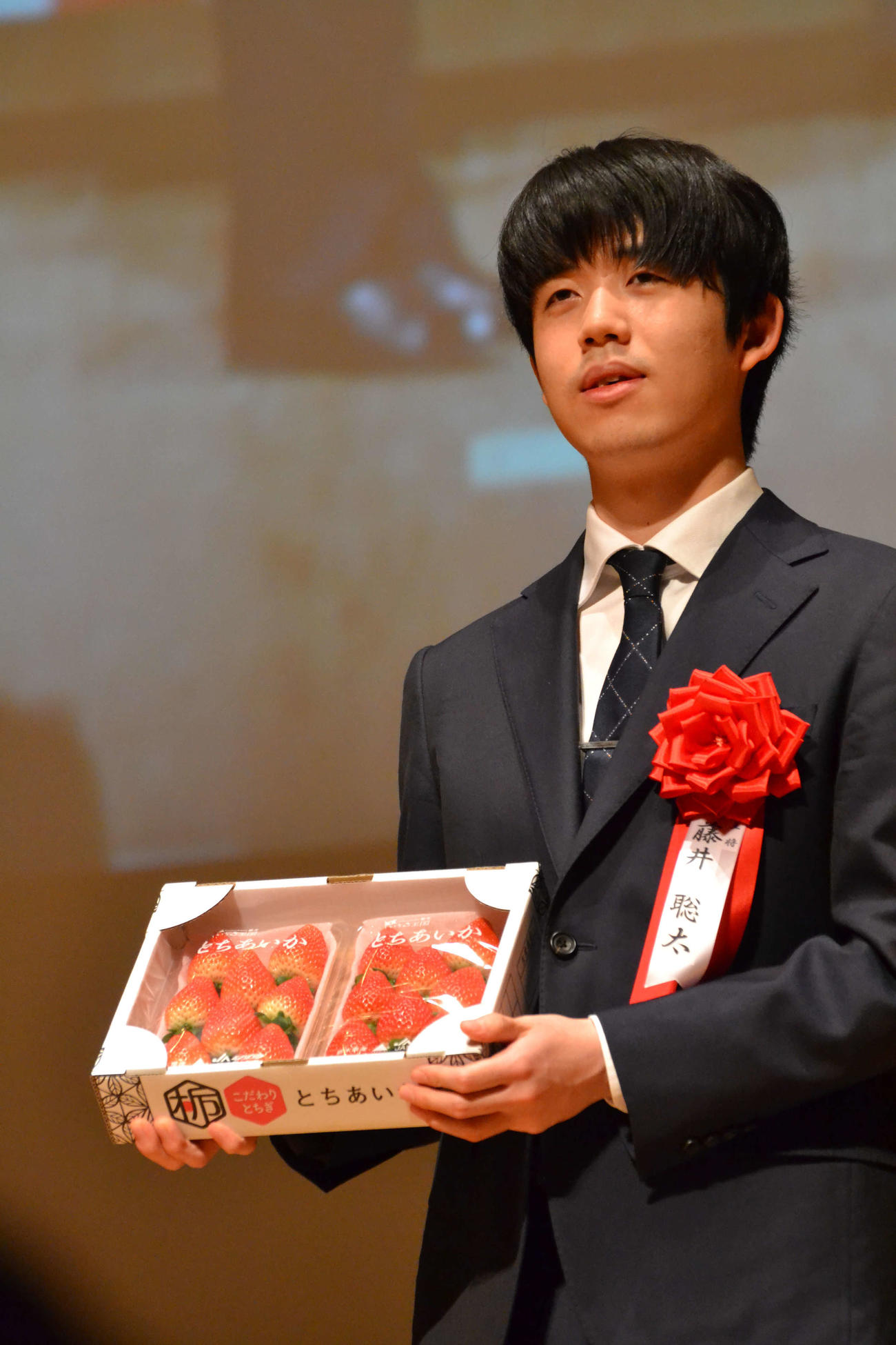 記念品贈呈で栃木特産のイチゴ「とちあいか」を手にする藤井聡太王将