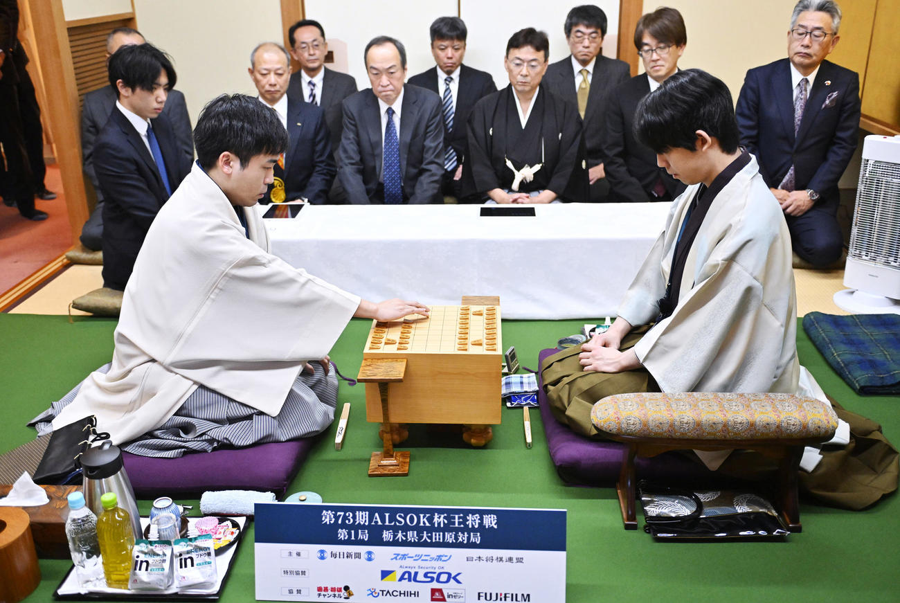 第73期王将戦七番勝負の第1局、初手を指す挑戦者の菅井八段（左）。右は藤井王将（代表撮影）